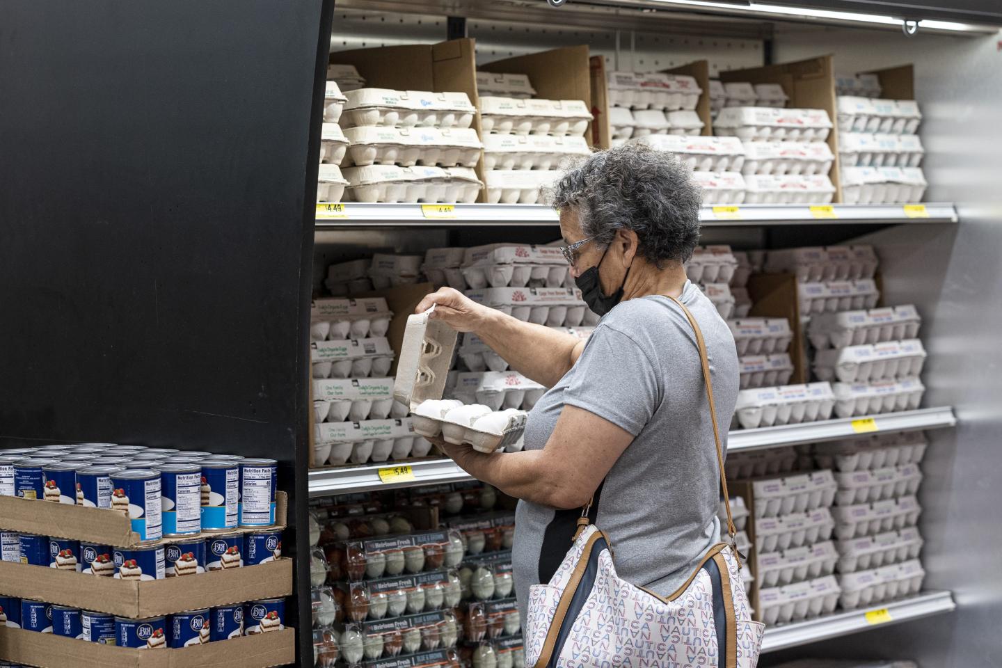 Woman checking eggs at a grocery store