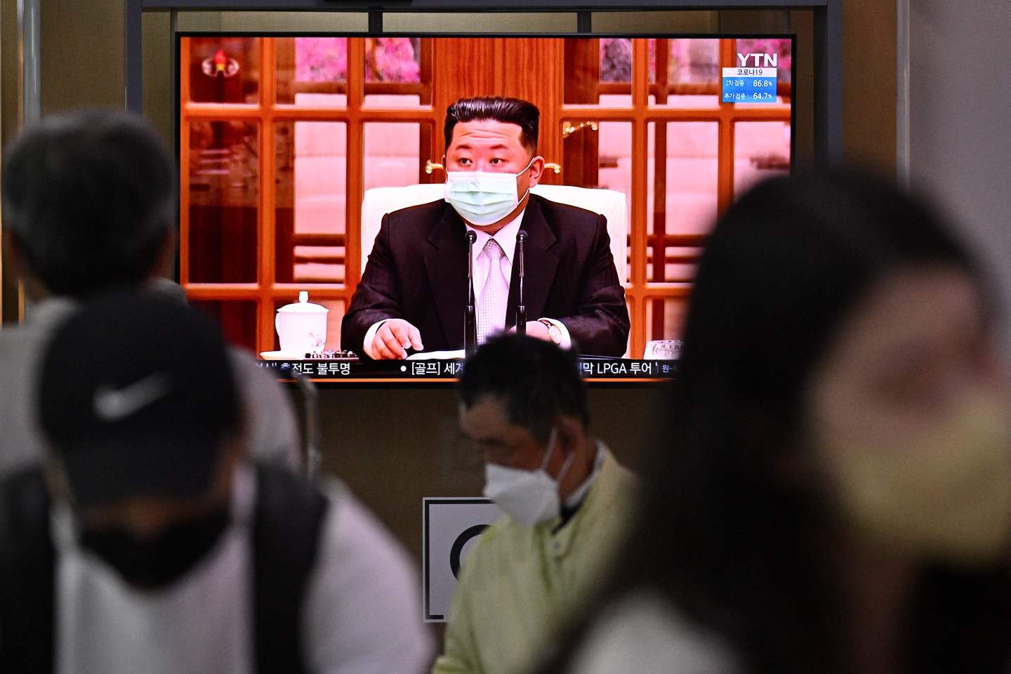 People sit near a screen showing a news broadcast at a train station in Seoul on May 12 of North Koreas leader Kim Jong Un appearing in a face mask on television for the first time to order nationwide lockdowns after the North confirmed its first-ever Covid-19 cases.