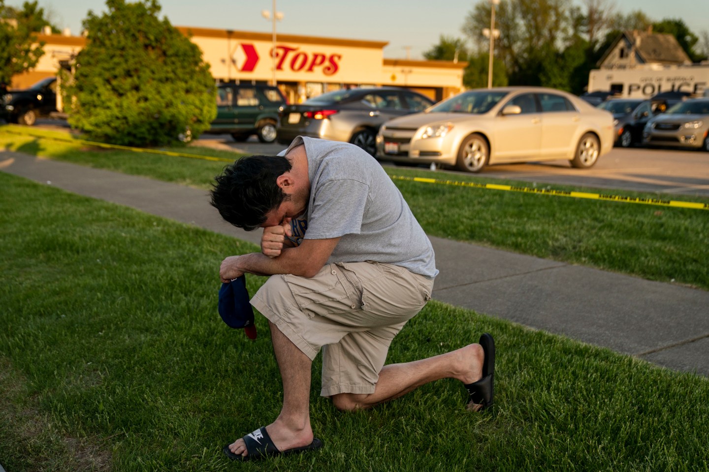 Jesse Gordon of Buffalo, pays his respects as people gather at the scene of a mass shooting at Tops Friendly Market.