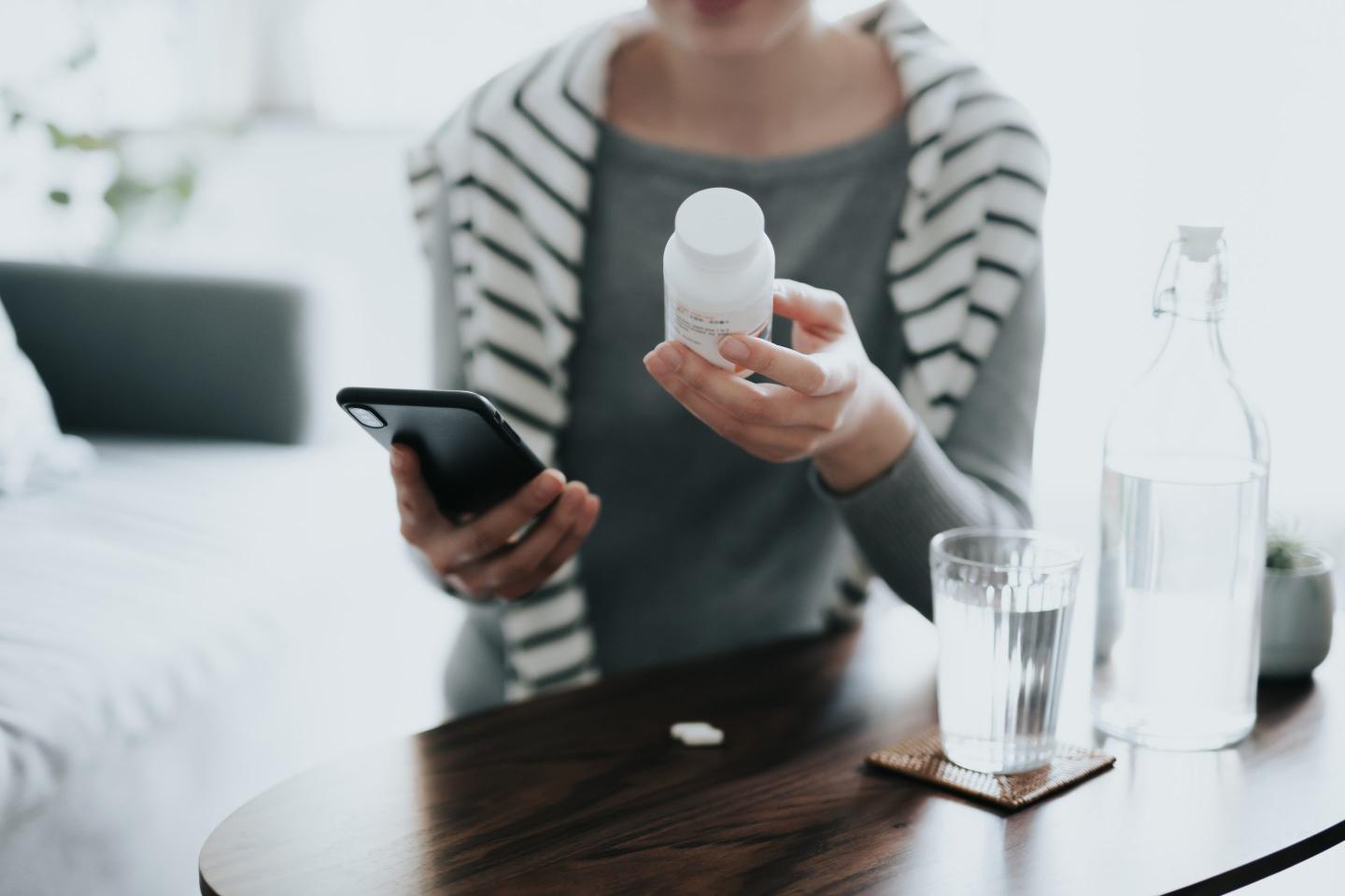 Young woman holds a prescription bottle