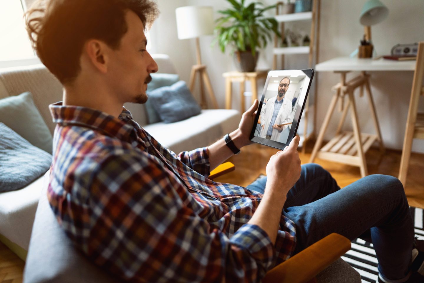 Man at home having a video conference with his doctor