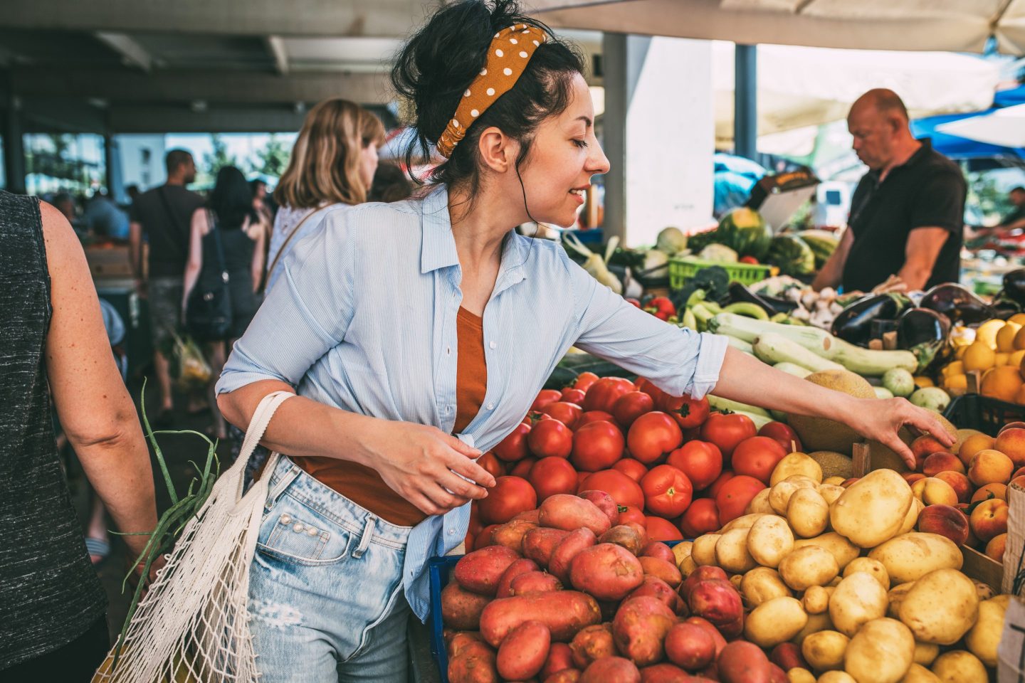 A woman buys vegetables and fruits at the market
