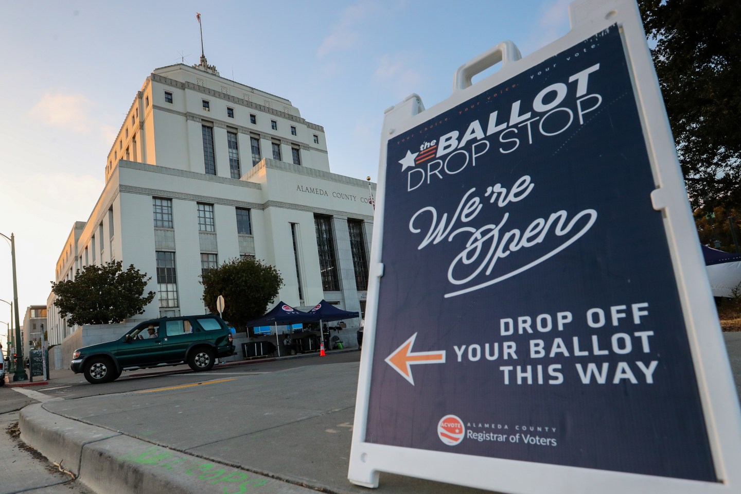 Voters drop off their California Gubernatorial Recall Election ballots at a drive-thru drop-off station outside the Alameda County Superior Courthouse in Oakland, Calif.