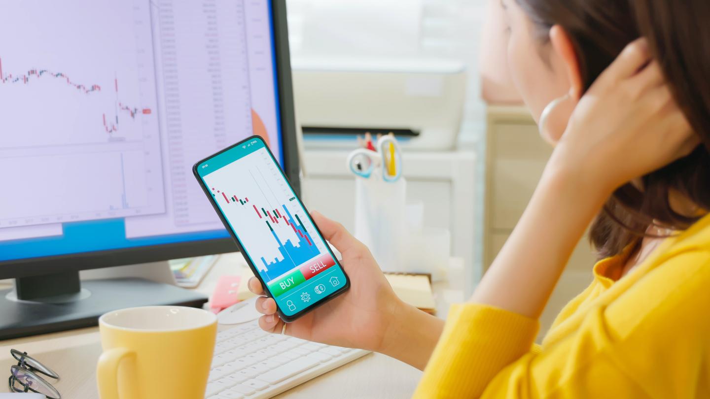 asian woman has stock market or cryptocurrency investment from home by smart phone and she is depressed about her failure