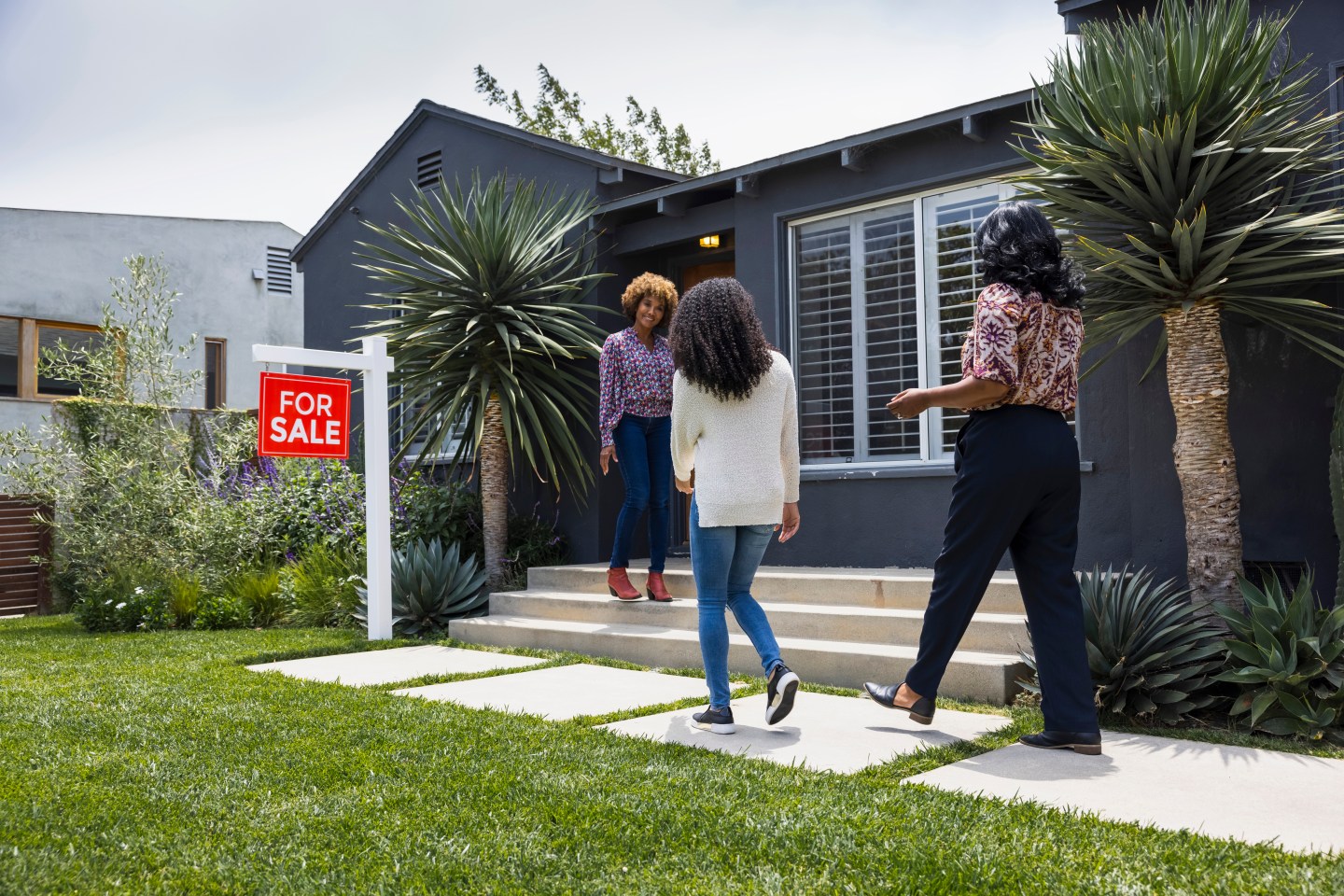 Stock photo of people looking at a house for sale.