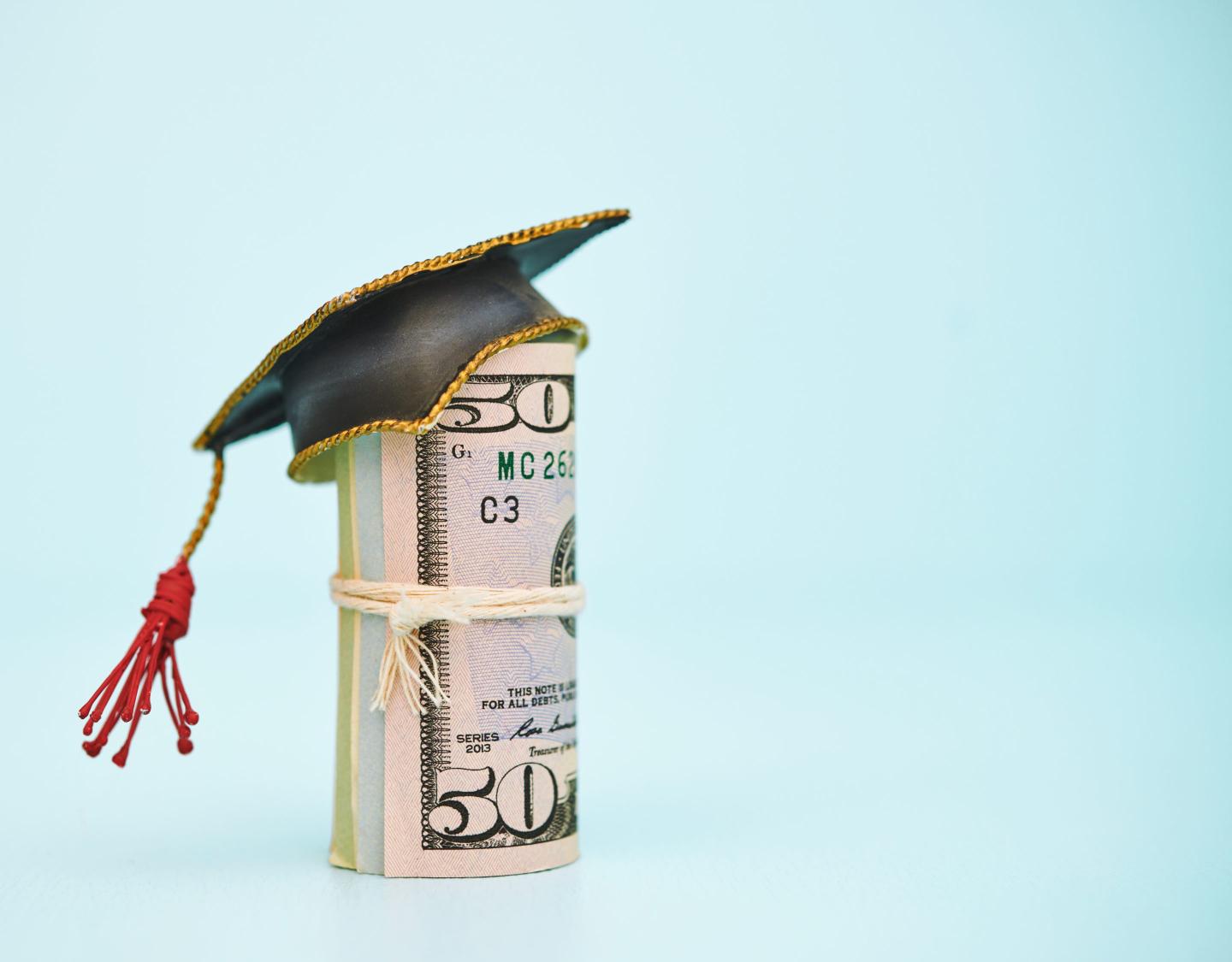 An illustration of money and a graduation cap.