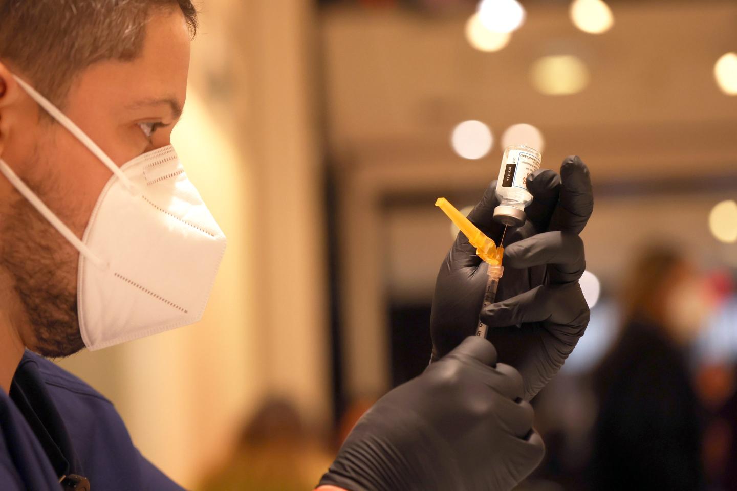 Jatniel Hernandez fills syringes with COID-19 vaccine