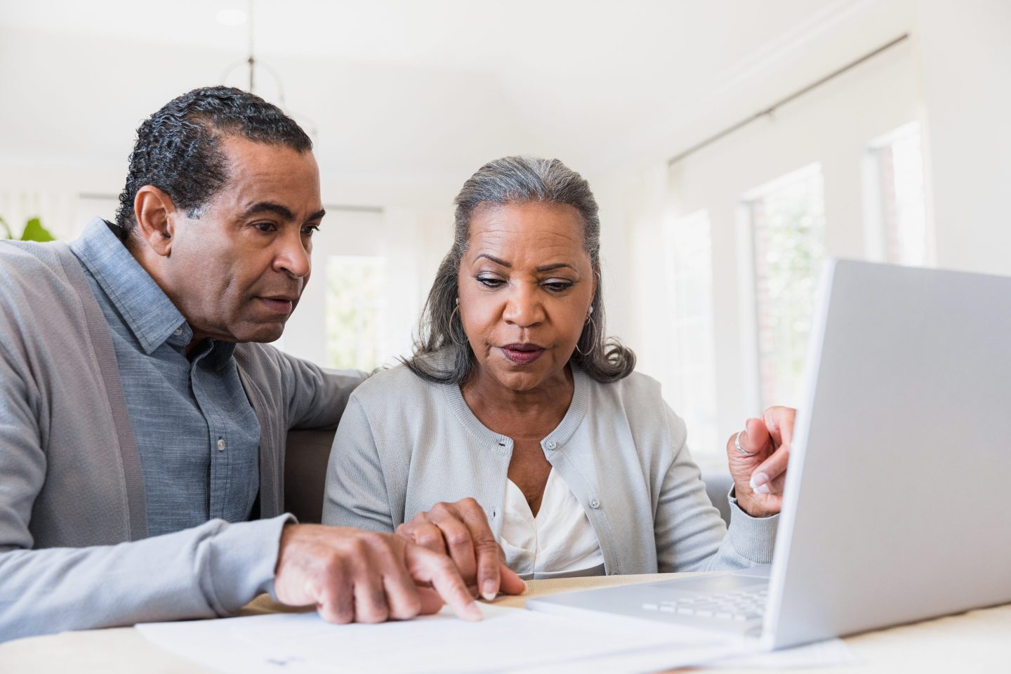 Man and woman sitting in front of laptop figuring out finances