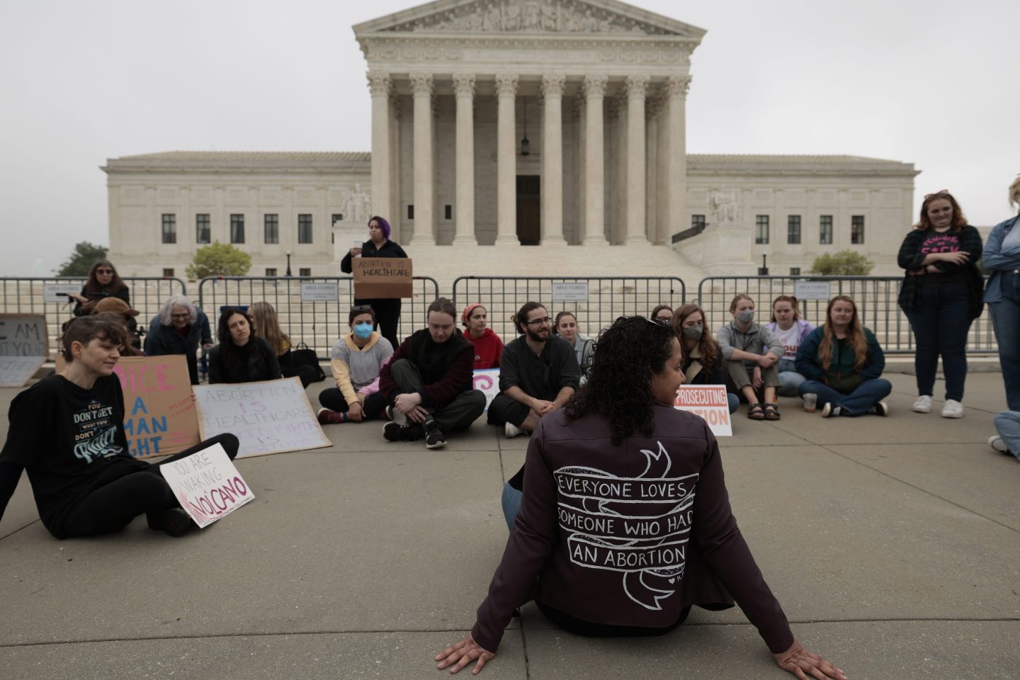 Demonstrators sit outside the Supreme Court building