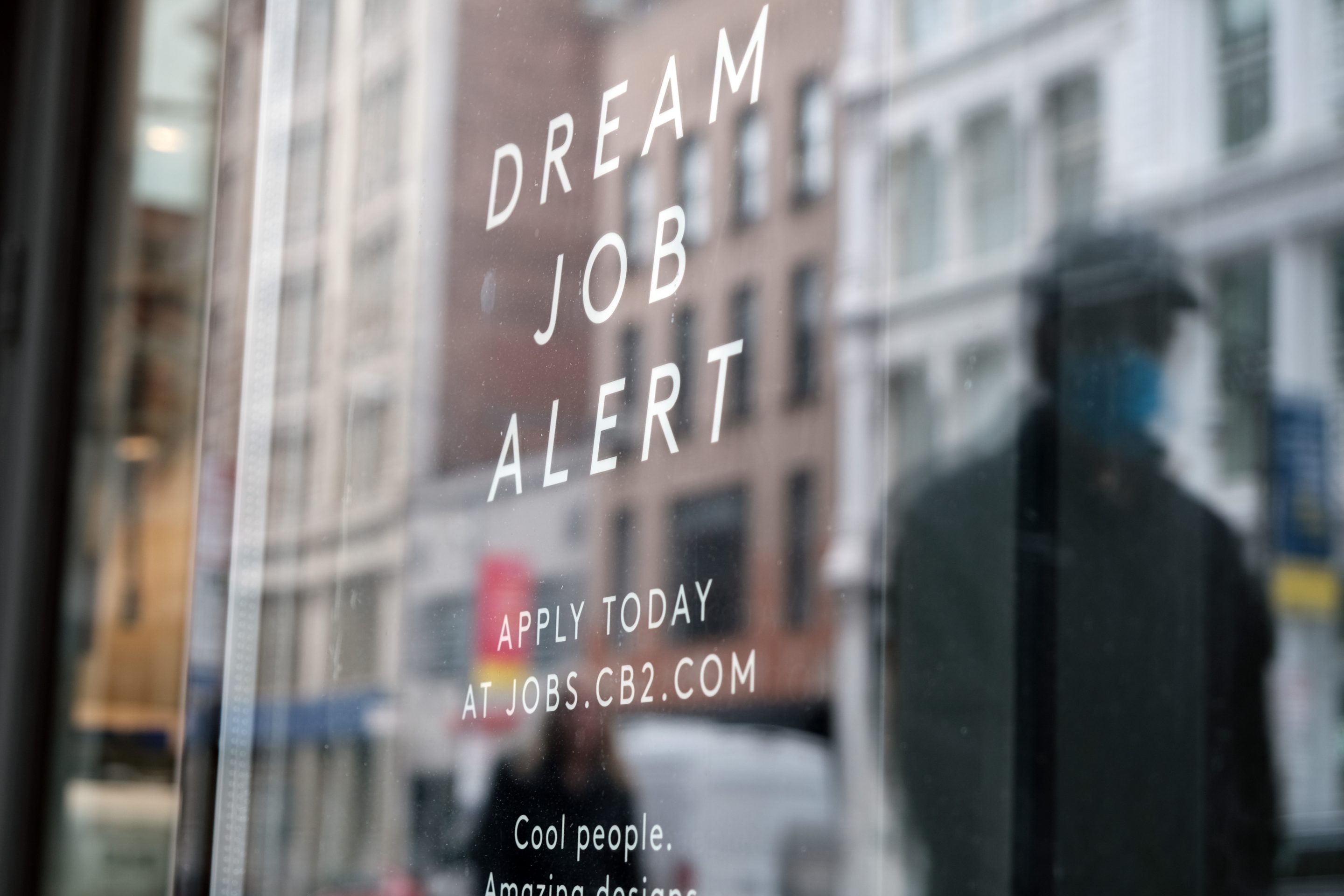 now hiring ad in a store window