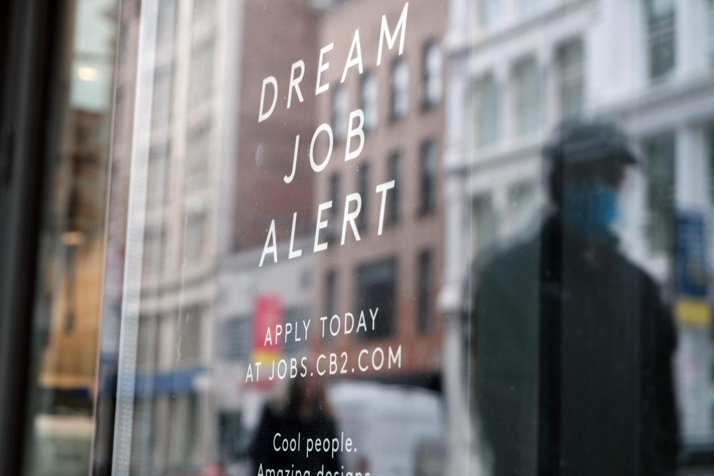 now hiring ad in a store window