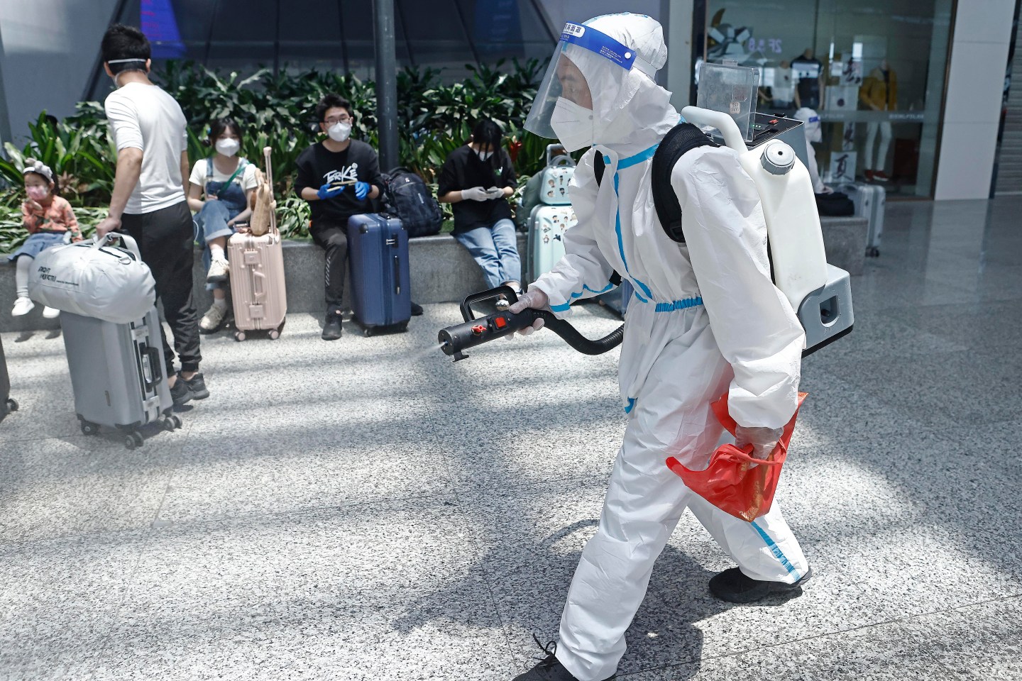 A staff member in a protective suit sprays disinfectant at Hongqiao Railway Station in Shanghai.