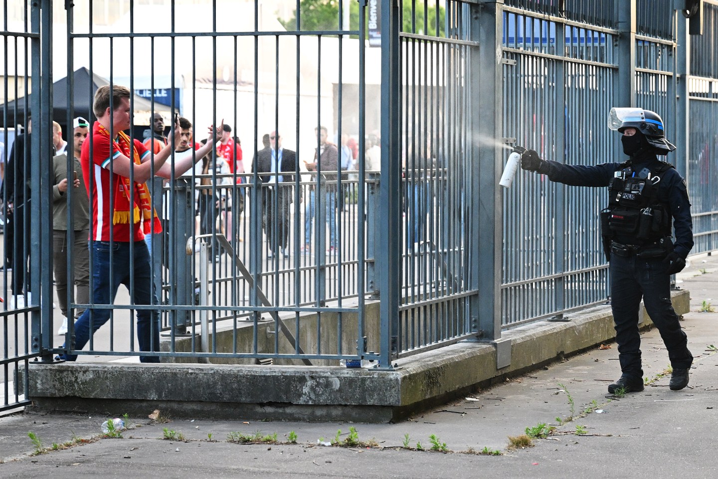PARIS, FRANCE - MAY 28: Police spray tear gas at Liverpool fans outside the stadium as they queue prior to the UEFA Champions League final match between Liverpool FC and Real Madrid at Stade de France on May 28, 2022 in Paris, France. (Photo by Matthias Hangst/Getty Images)