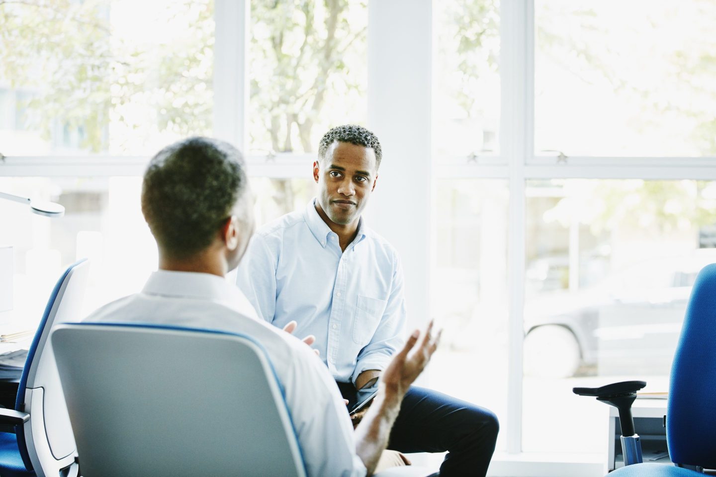 Businessmen in discussion at office workstation