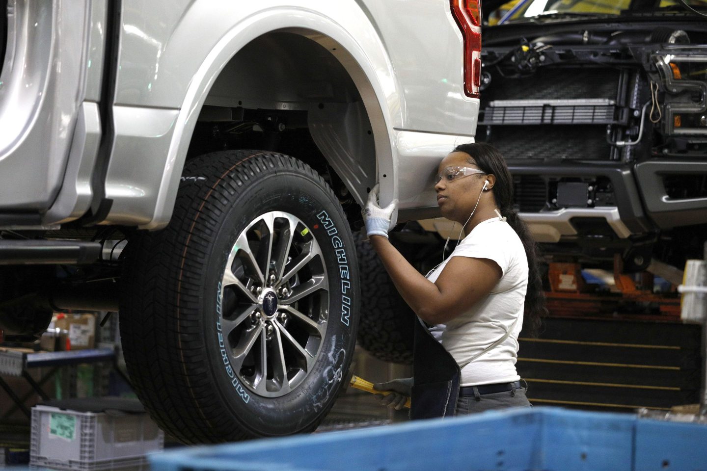 A Ford factory worker inspects an F-150 truck.