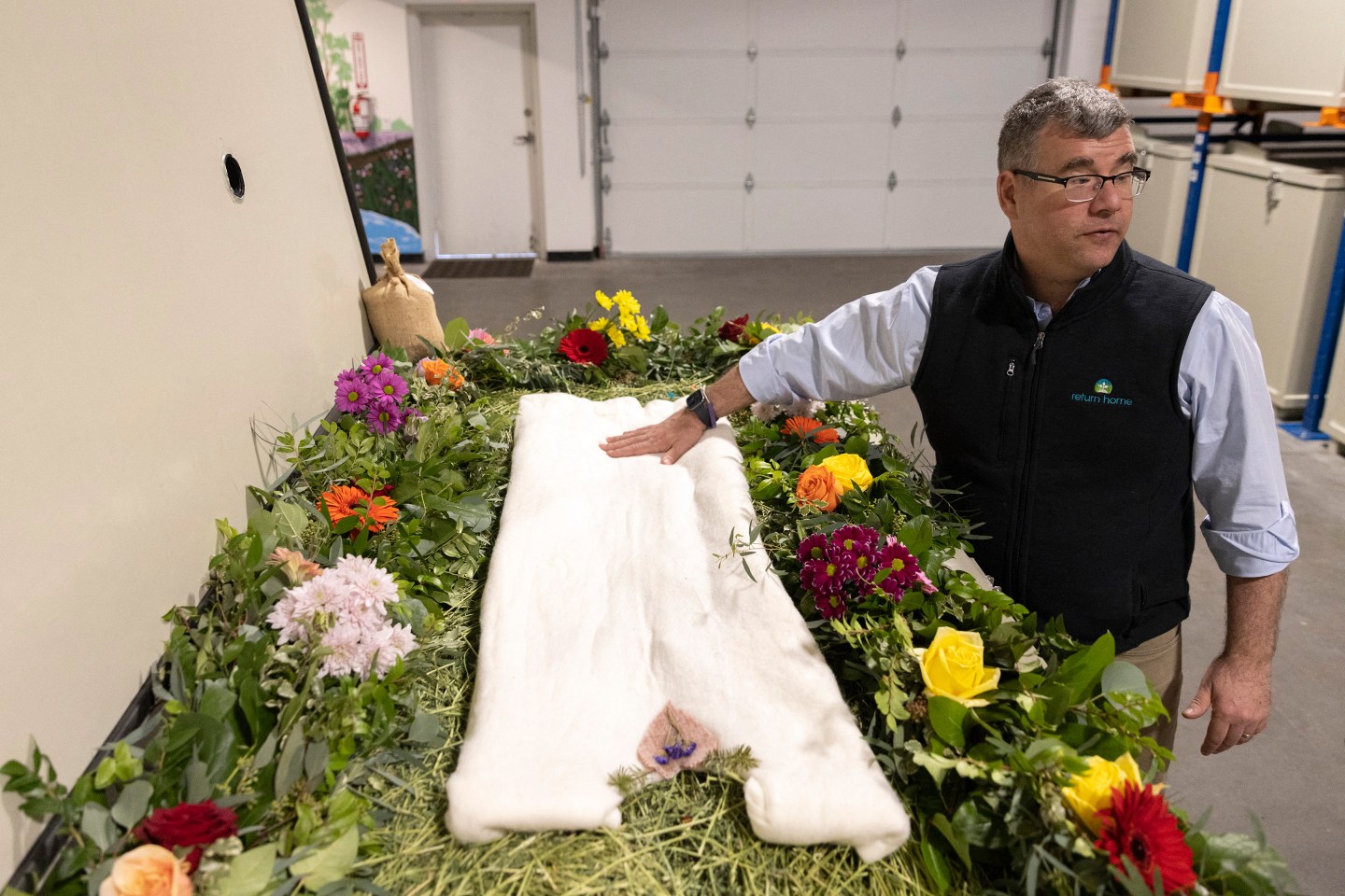 TOPSHOT &#8211; Return Home CEO Micah Truman shows a demonstration &#8220;vessel&#8221; for the deceased, decorated with flowers and compostable mementos on top of a bed of straw by Return Home, during a tour of the funeral home which specializes in human composting in Auburn, Washington on March 14, 2022. &#8211; Washington in 2019 became the first in the United States to make it a legal alternative to cremation. (Photo by Jason Redmond / AFP) (Photo by JASON REDMOND/AFP via Getty Images)