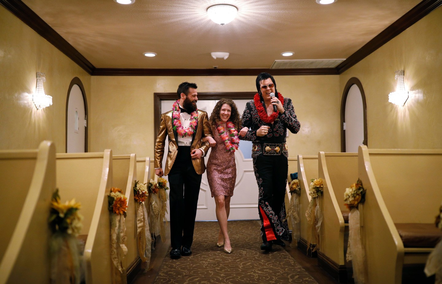 Elvis impersonator Brendan Paul, right, walks down the aisle during a wedding ceremony for Katie Salvatore, center, and Eric Wheeler at the Graceland Wedding Chapel in Las Vegas. Authentic Brands Group sent cease-and-desist letters earlier this month to multiple chapels, saying they had to comply by the end of May, the Las Vegas Review-Journal reported.