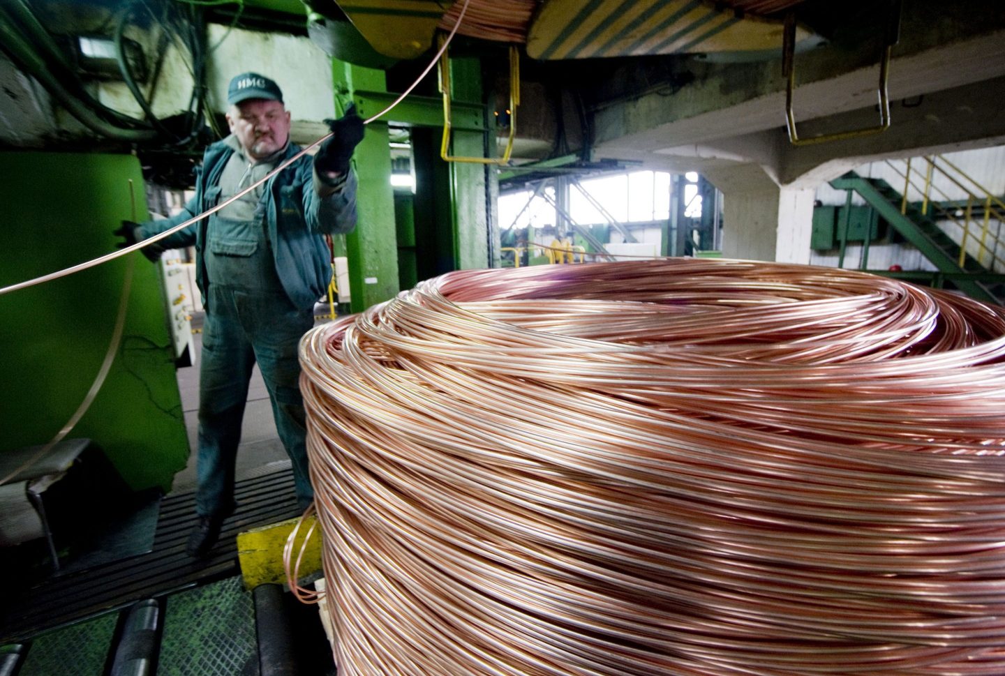 An operator guides high grade copper wire rods on to a spooling machine at the KGHM Polska Miedz SA owned Cedynia rolling mill in Orsk, Poland, on Wednesday, March 3, 2010.