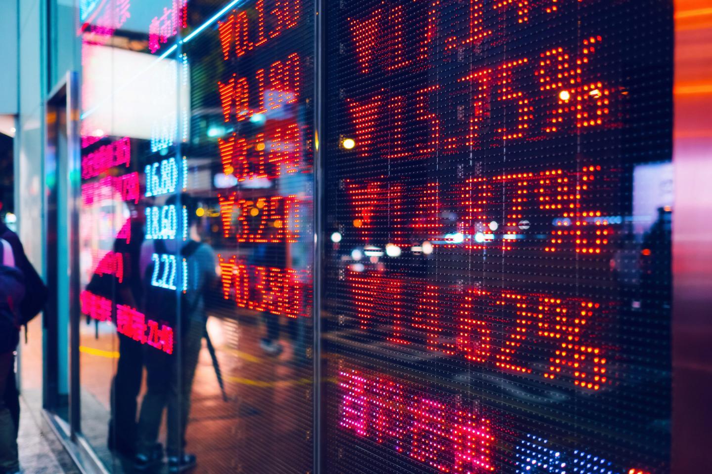 A digital stock ticker board showing a column of declining values