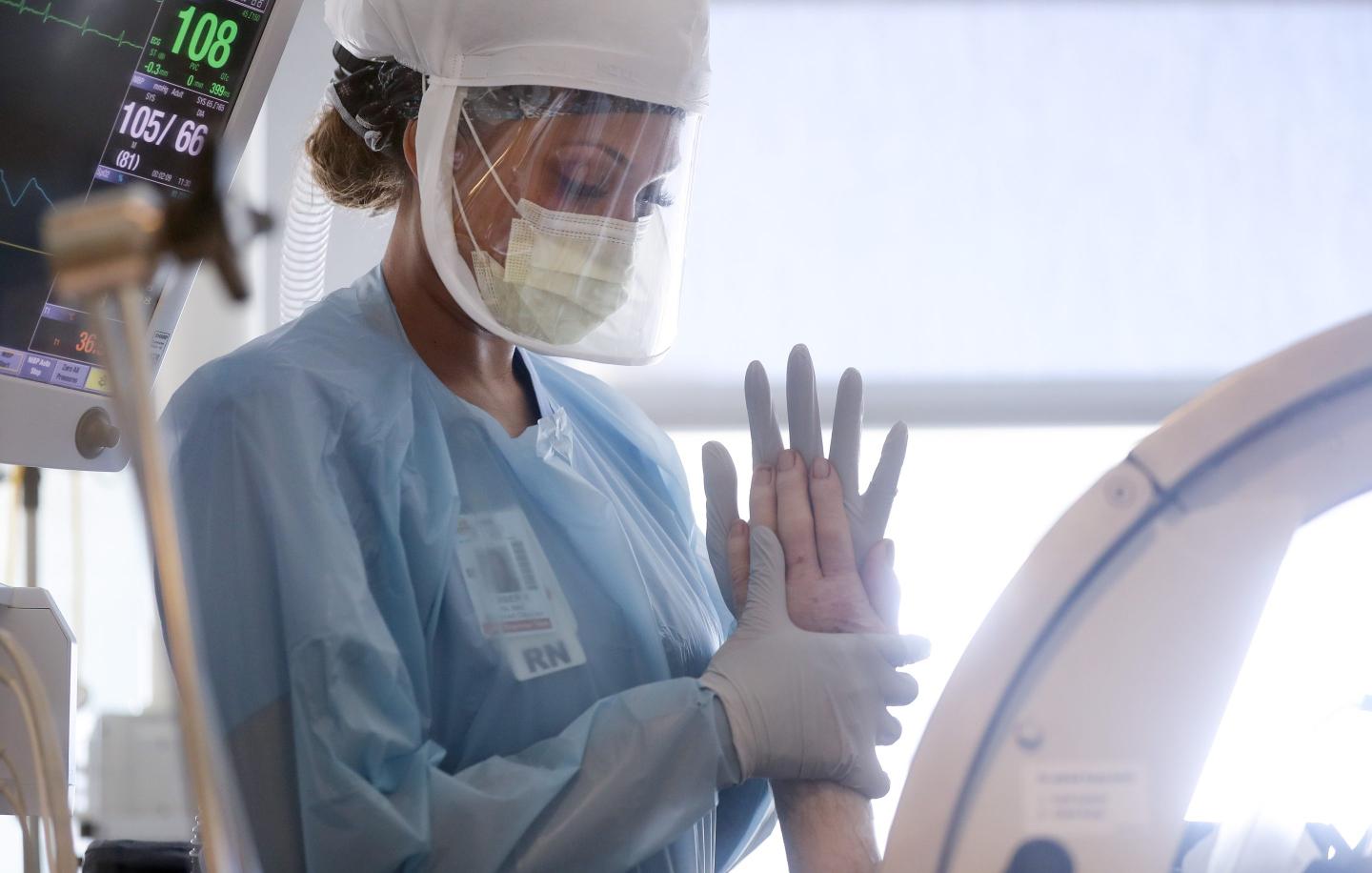 A nurse in California assists a COVID patient with hand exercises