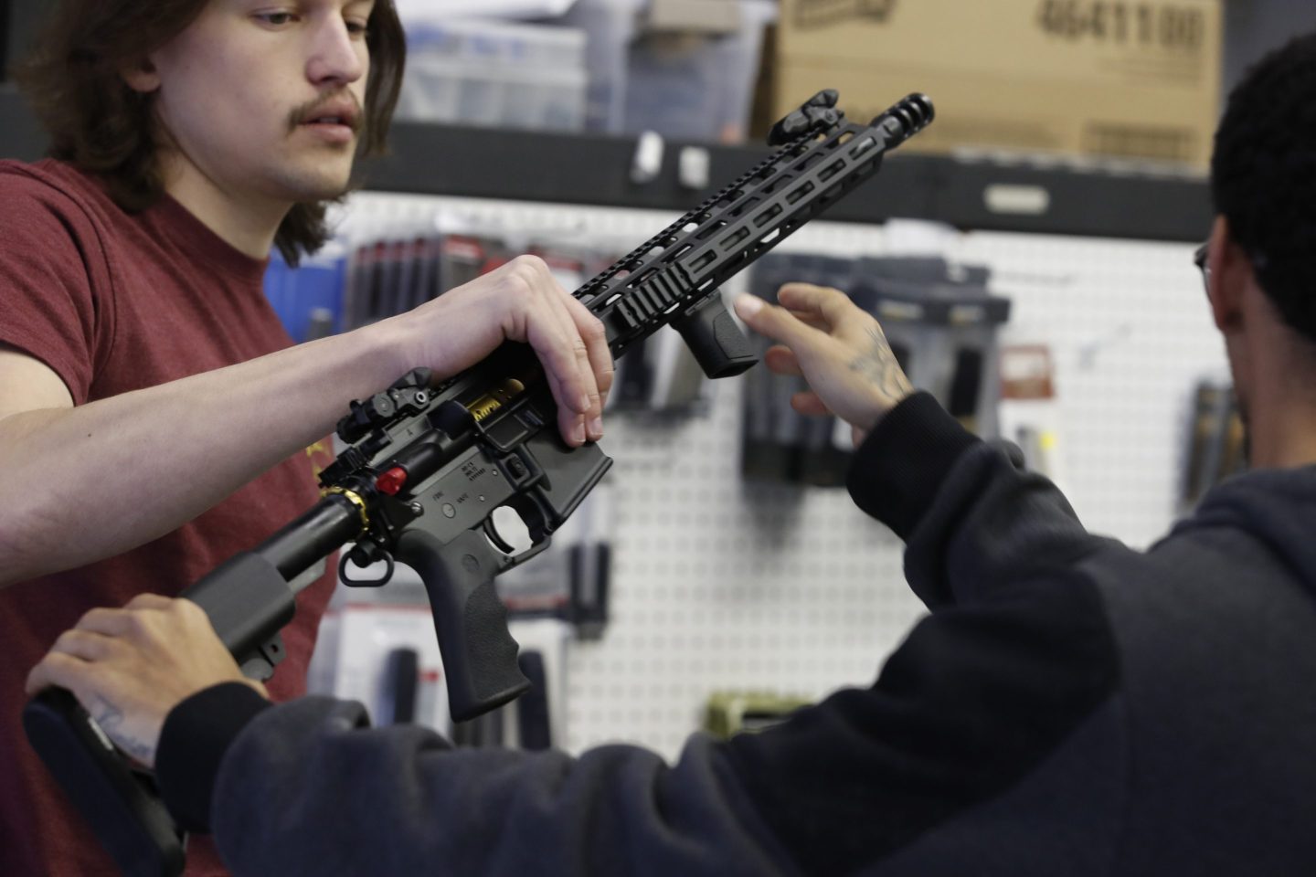 A salesperson shows an AR-15 rifle to a customer at a store in Orem, Utah