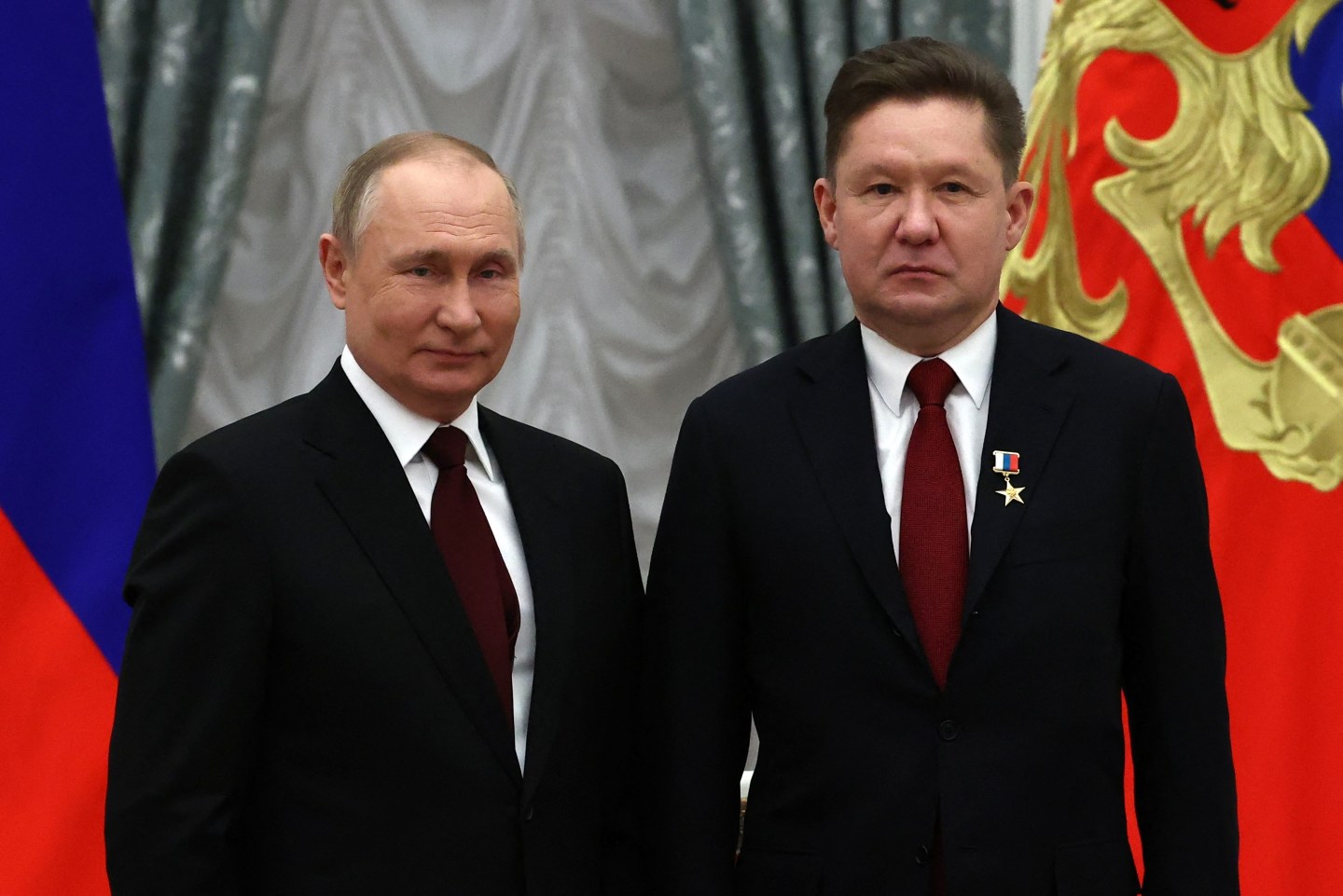 Russia's President Vladimir Putin (L) poses next to Gazprom CEO Alexei Miller after awarding him with the title of "Hero of Labor of the Russian Federation" during an award ceremony at the Kremlin in Moscow on February 2, 2022.