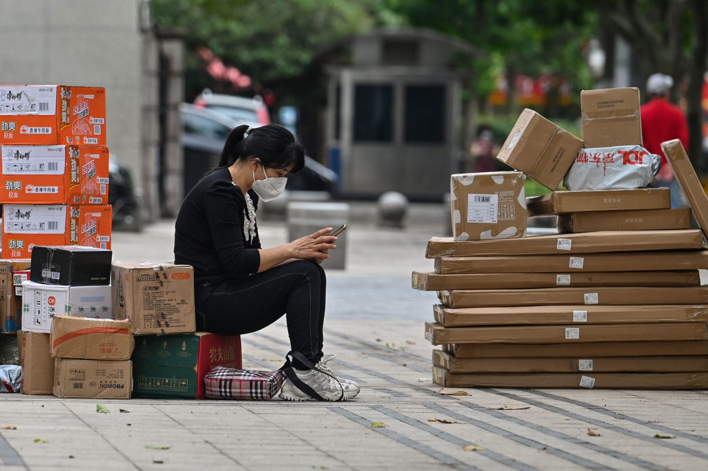 A woman in Shanghai sits next to boxes during the city's COVID lockdown