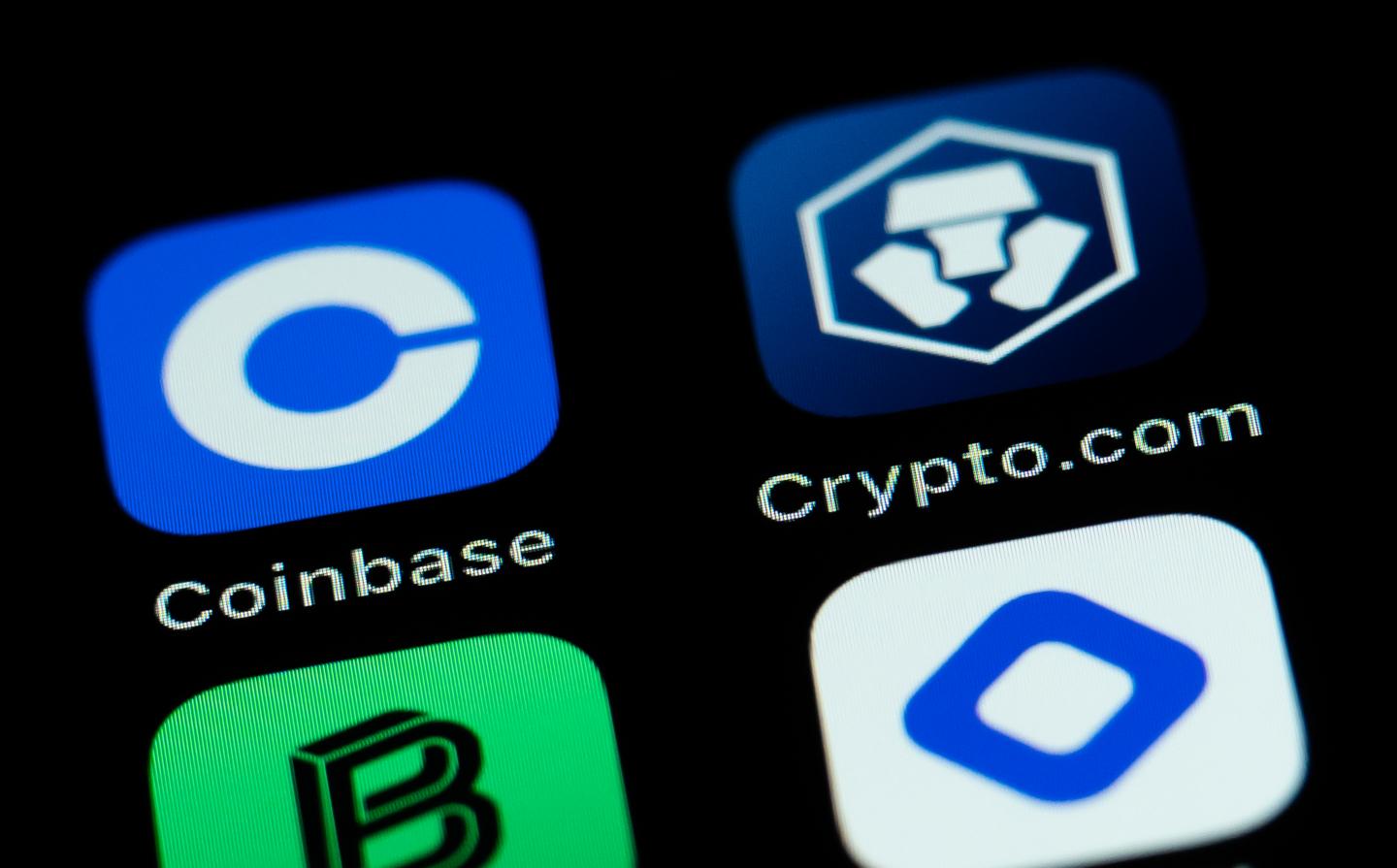 The application apps of cryptocurrency exchanges Coinbase and Crypto.com are seen on the display of an iPhone SE.