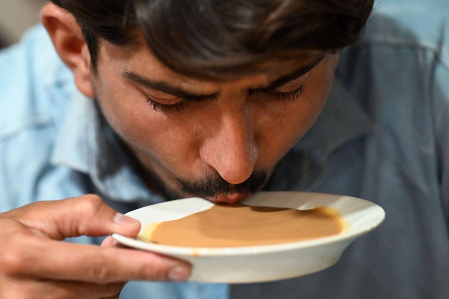 A Pakistani man sups tea from a saucer
