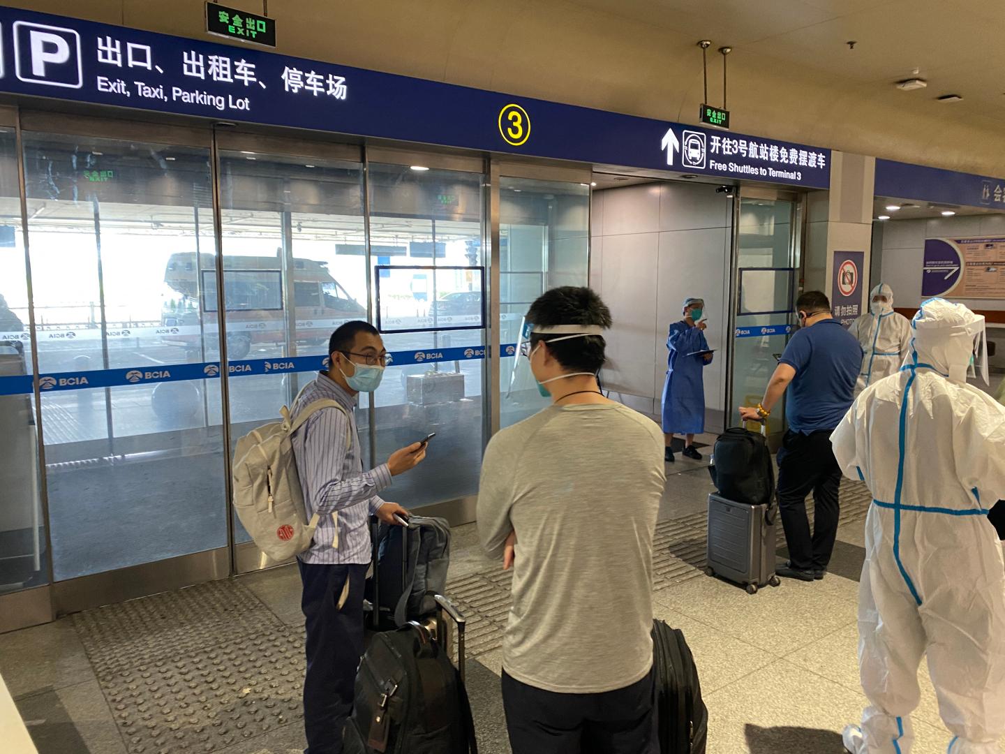 Inbound passengers wait to be taken to quarantine-designated destinations from the Beijing International Airport in Beijing on June 18, 2022.