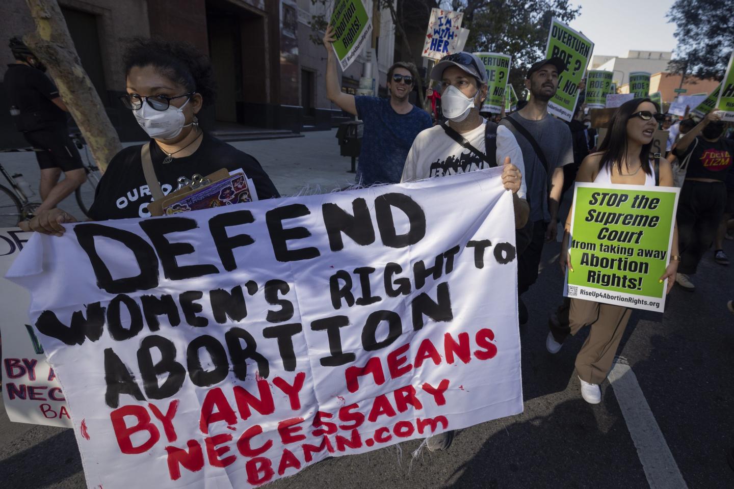 Photo of abortion rights advocates holding banners during protests over the Supreme Court's decision to overturn Roe v. Wade.