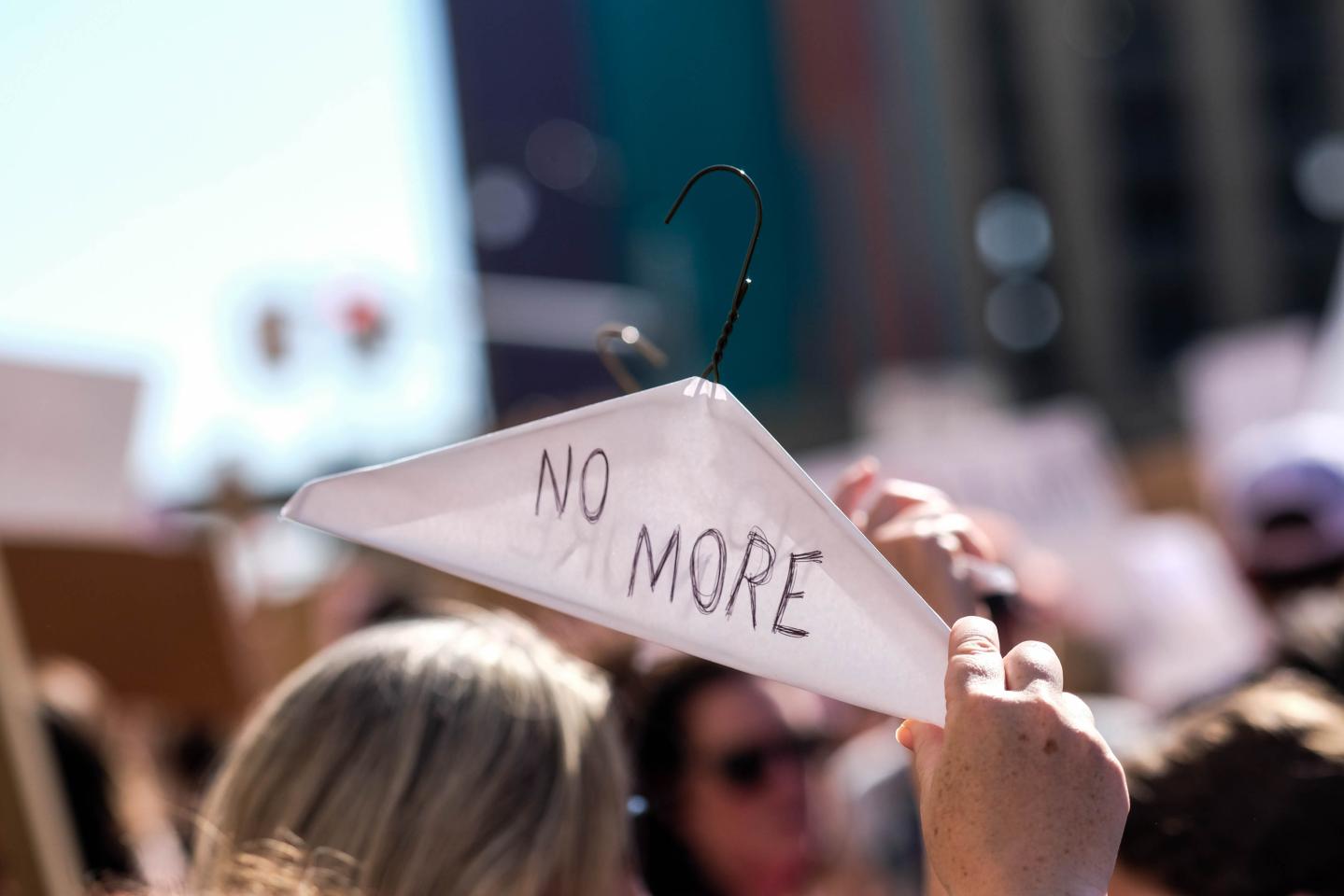 A protester holds up a coat hanger with 'No More' written on it during the demonstration. Hundreds of protesters turned out on the streets of Detroit, Michigan to protest the US Supreme Court's decision to overturn Roe v. Wade and abolish the constitutional right to abortion.