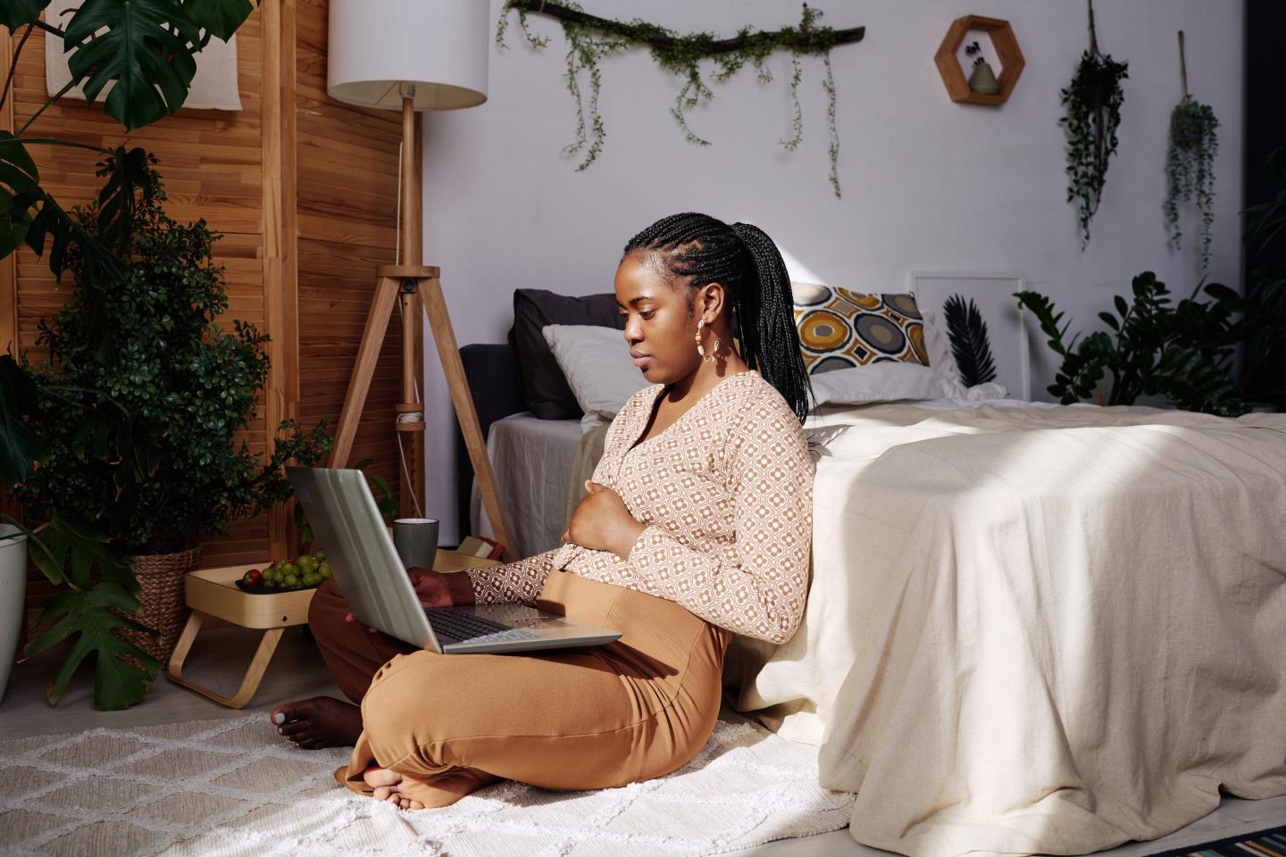 Woman sitting on floor with laptop on her lap