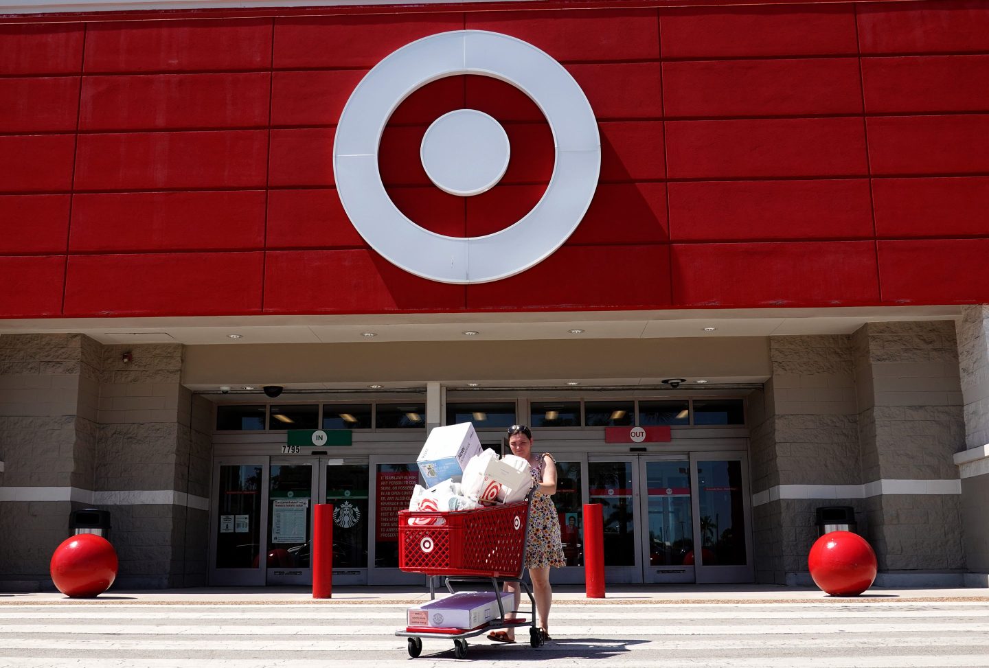 person pushing red shopping cart outside of a Target storefront