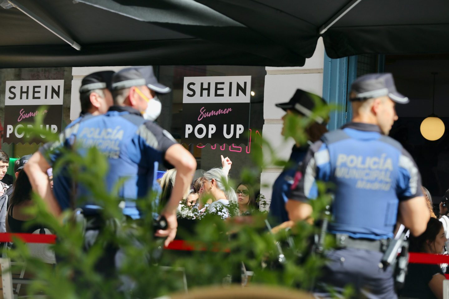 Police on stand by outside a Shein pop-up shop in Madrid, Spain