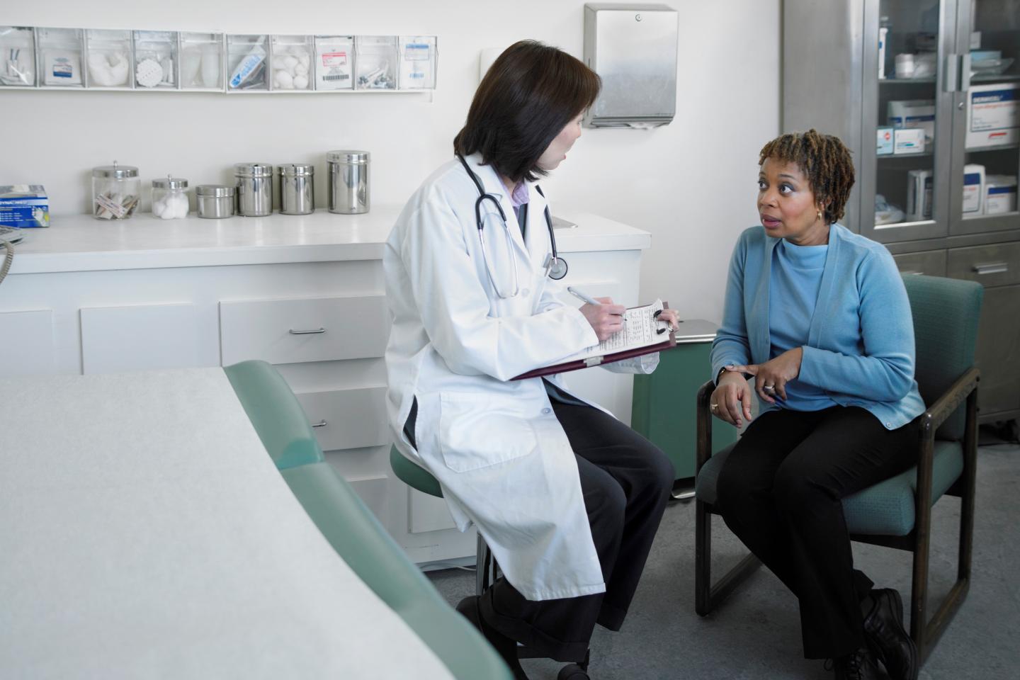 woman sitting in a chair talking with a doctor