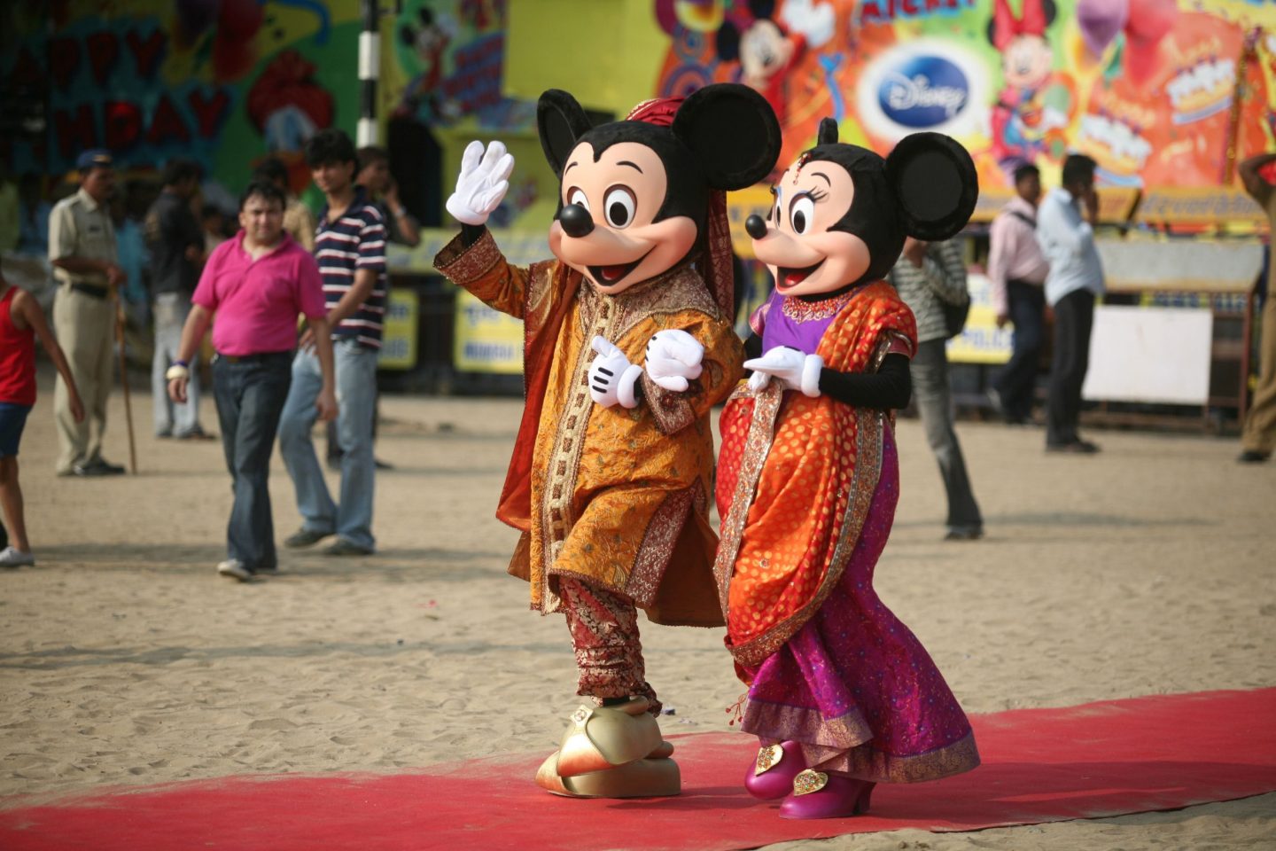 Mickey and Minnie Mouse, in traditional India dress, wave to crowds in Mumbai.