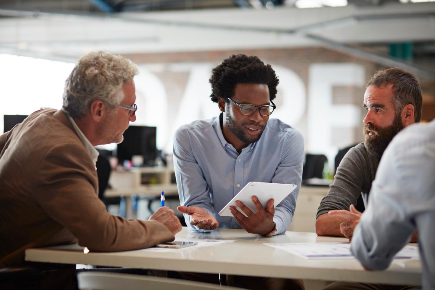 A Black worker with white colleagues