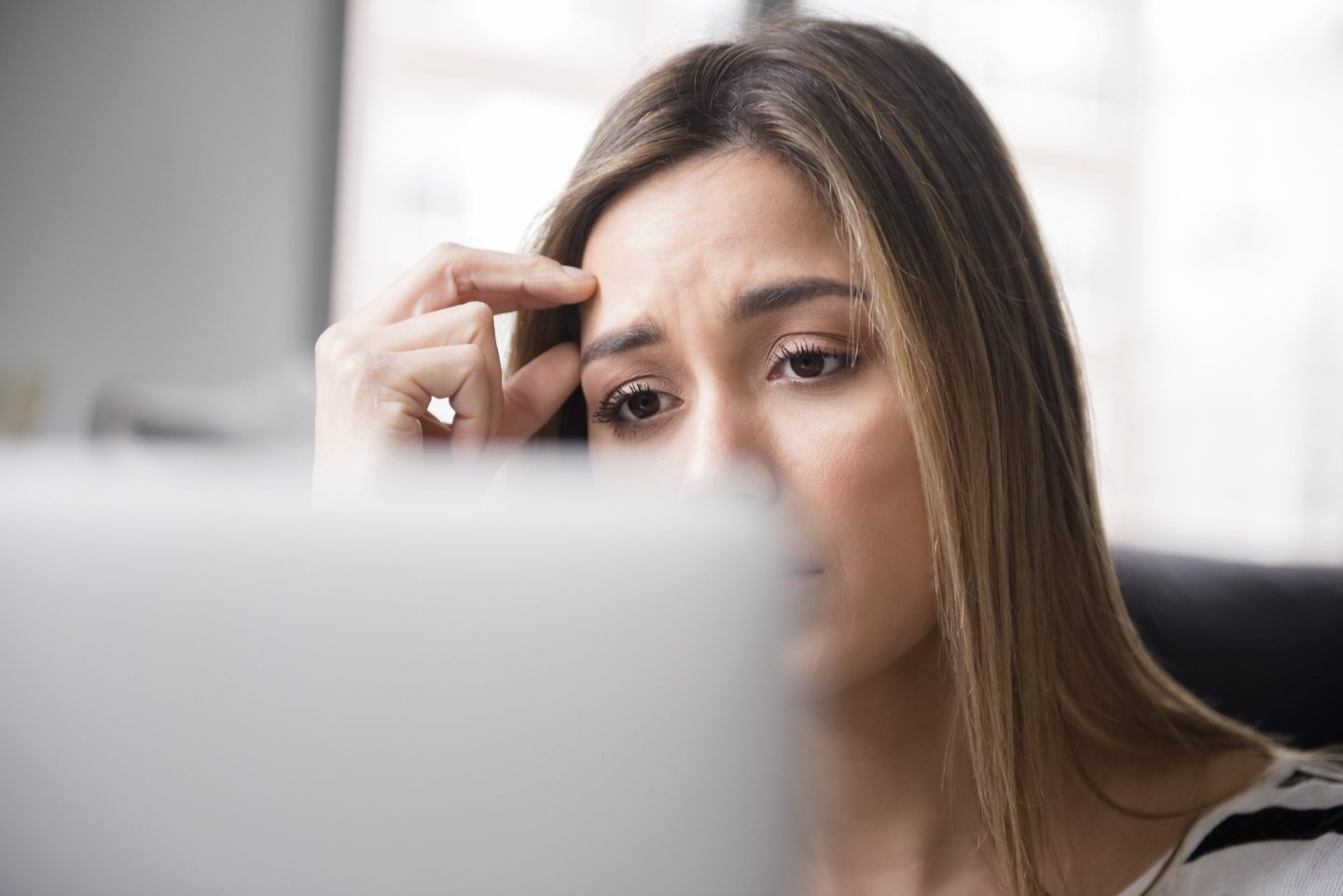 Worried-looking woman in front of laptop