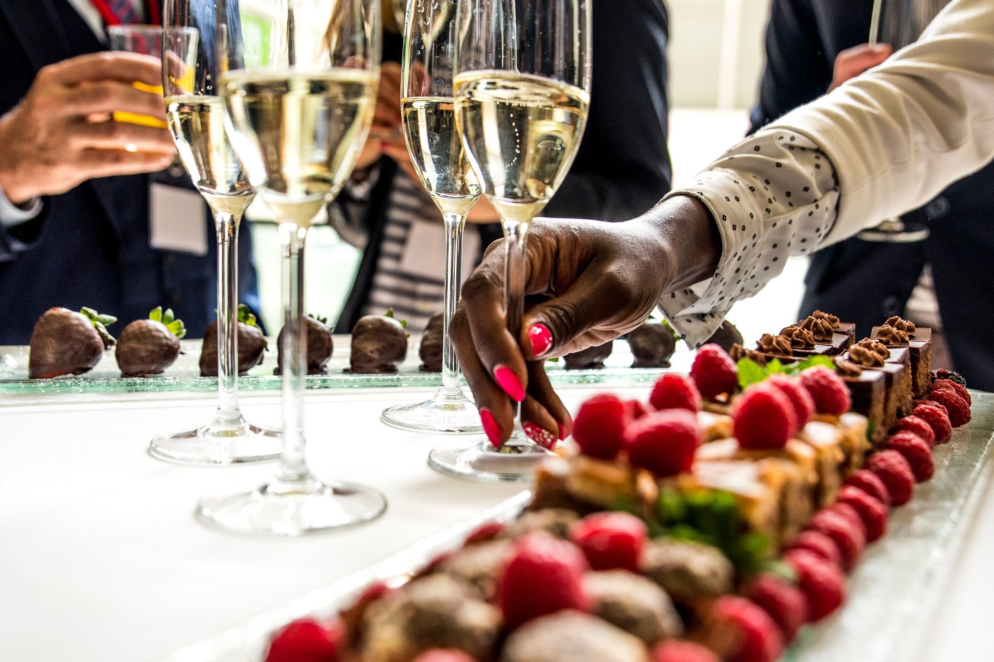 A woman takes a glass of Champagne at a social gathering