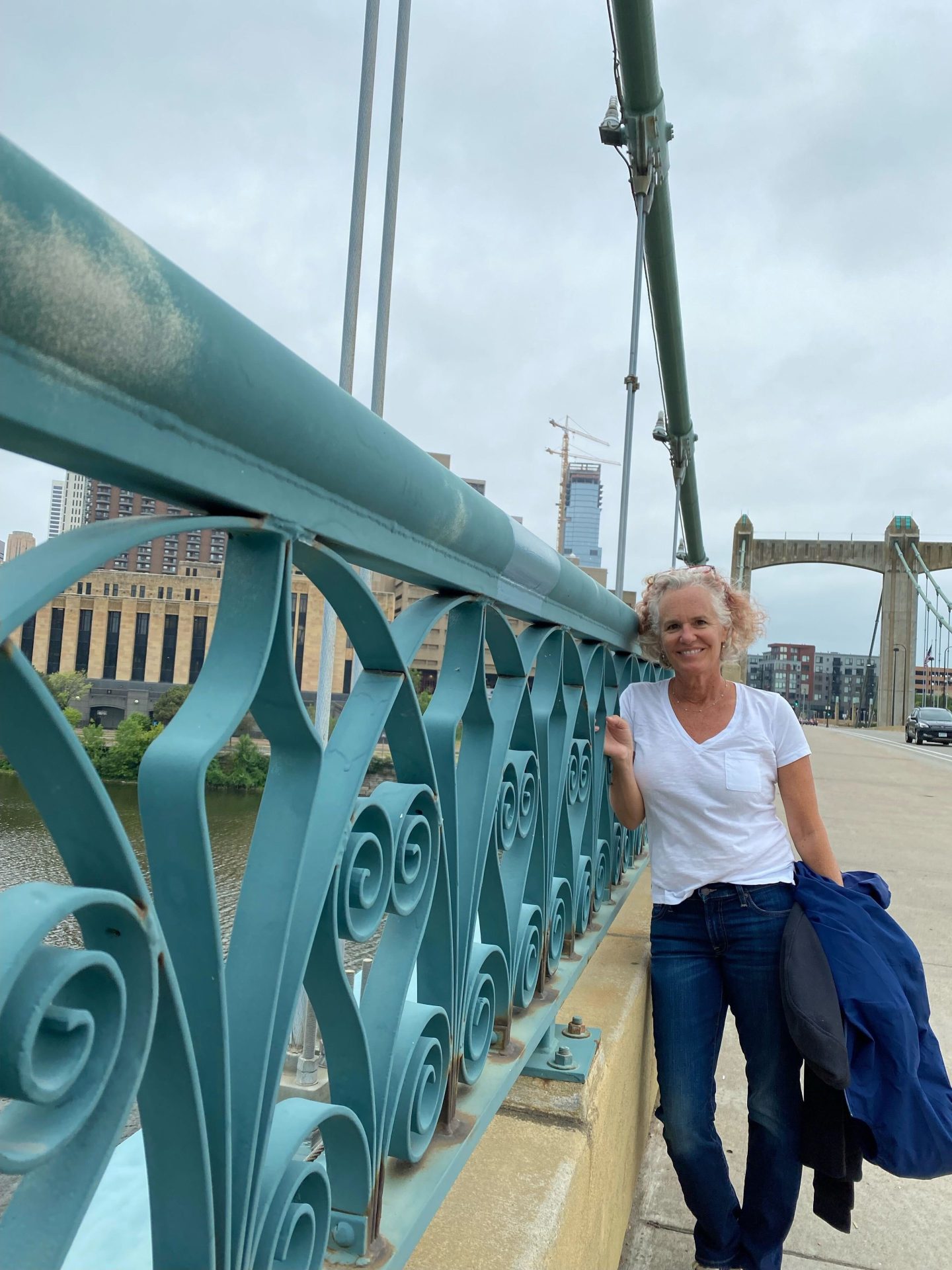 Nancy Wadsworth stands smiling on bridge