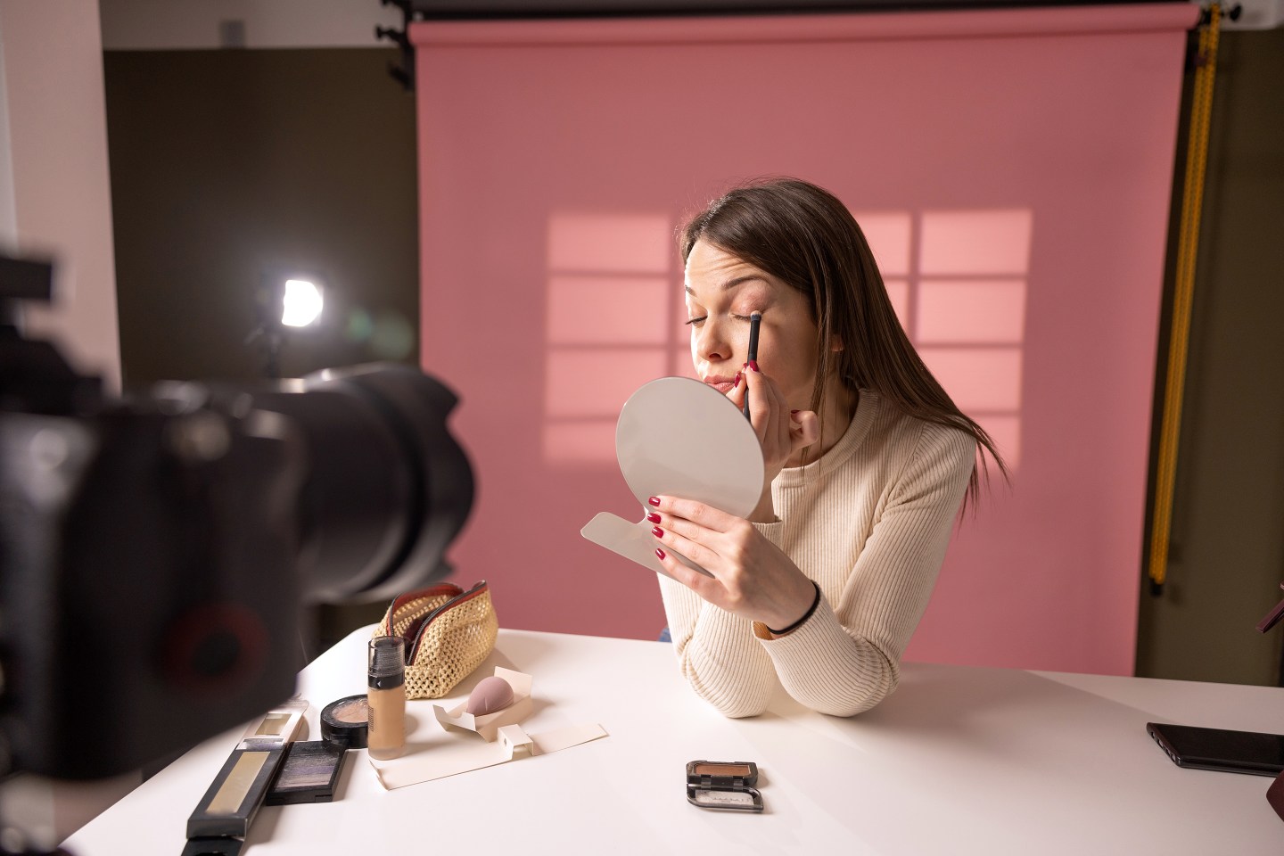 Young woman recording a makeup tutorial.