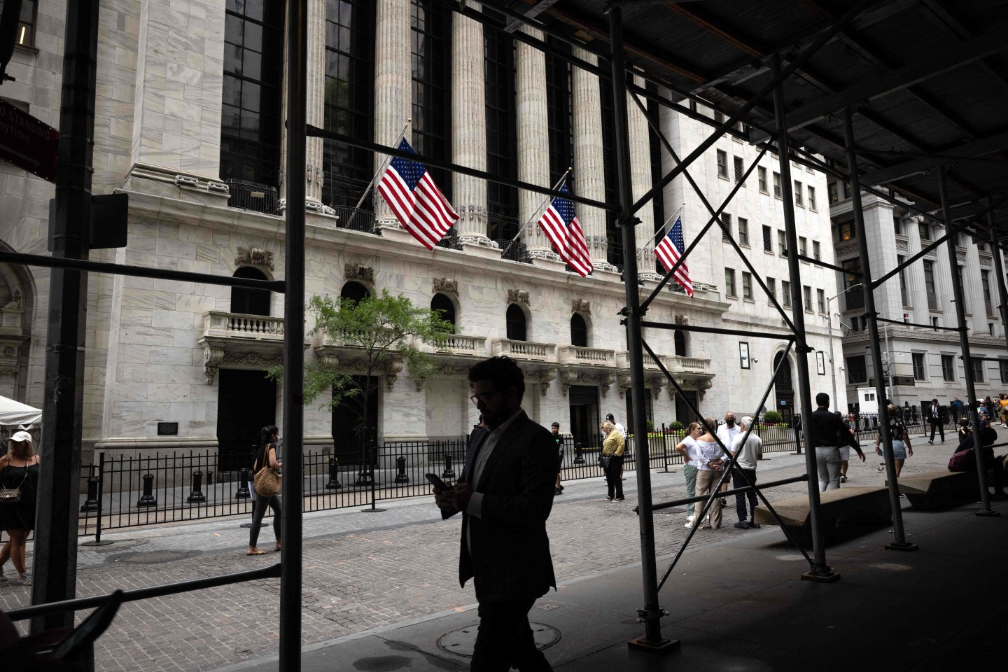 People walk past the New York Stock Exchange in New York on June 16, 2022. (