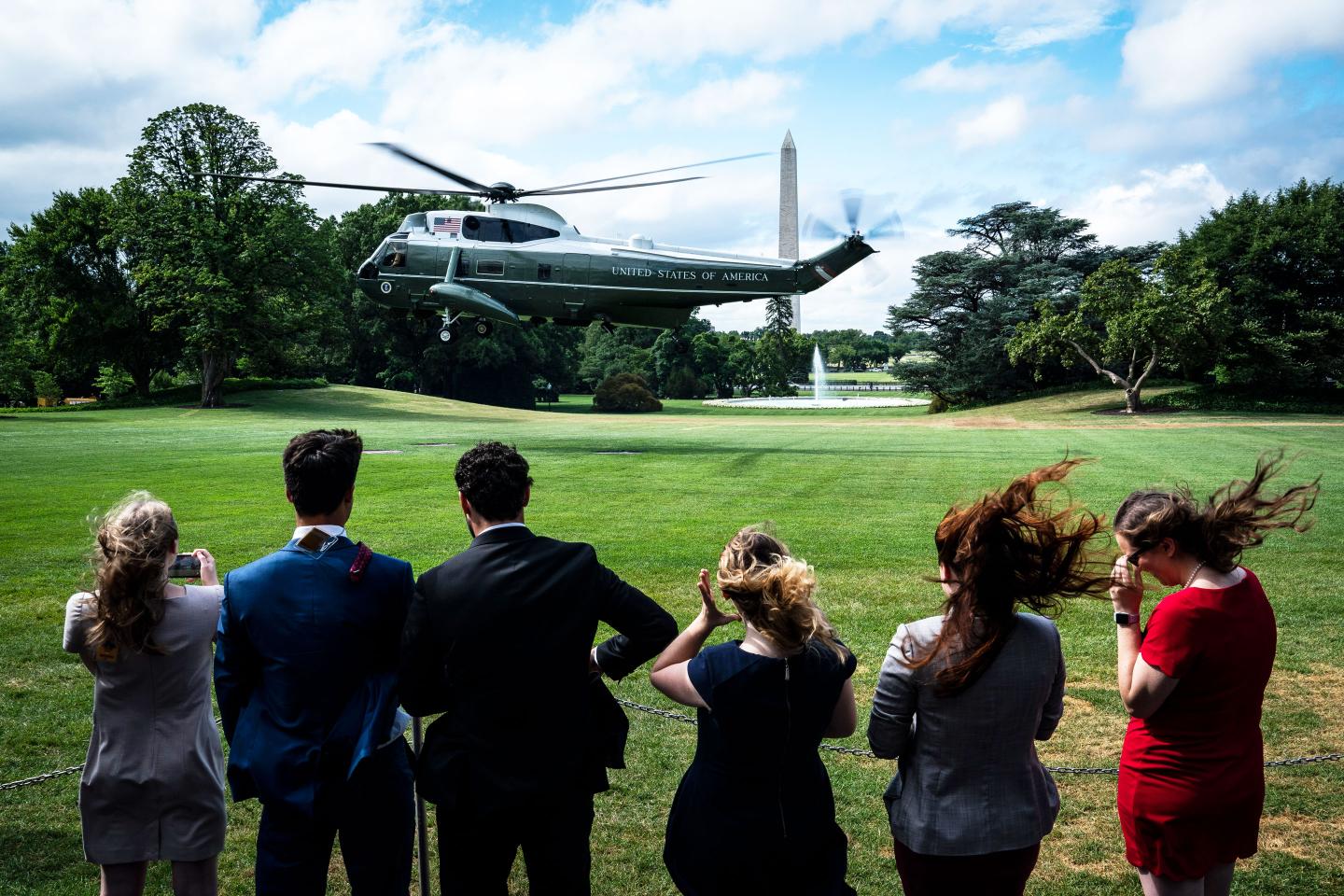 White House interns watch as Marine One departs from the South Lawn of the White House