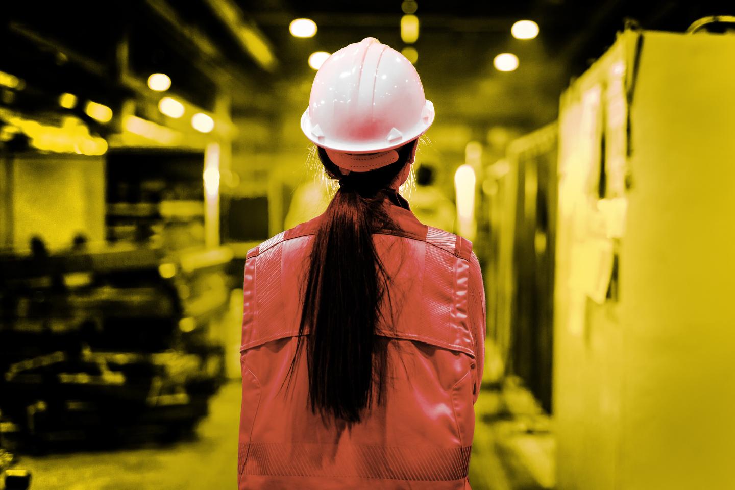woman in a safety vest on a factory floor