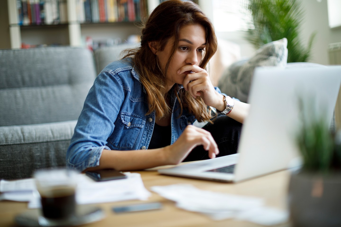 Worried young woman working at home.