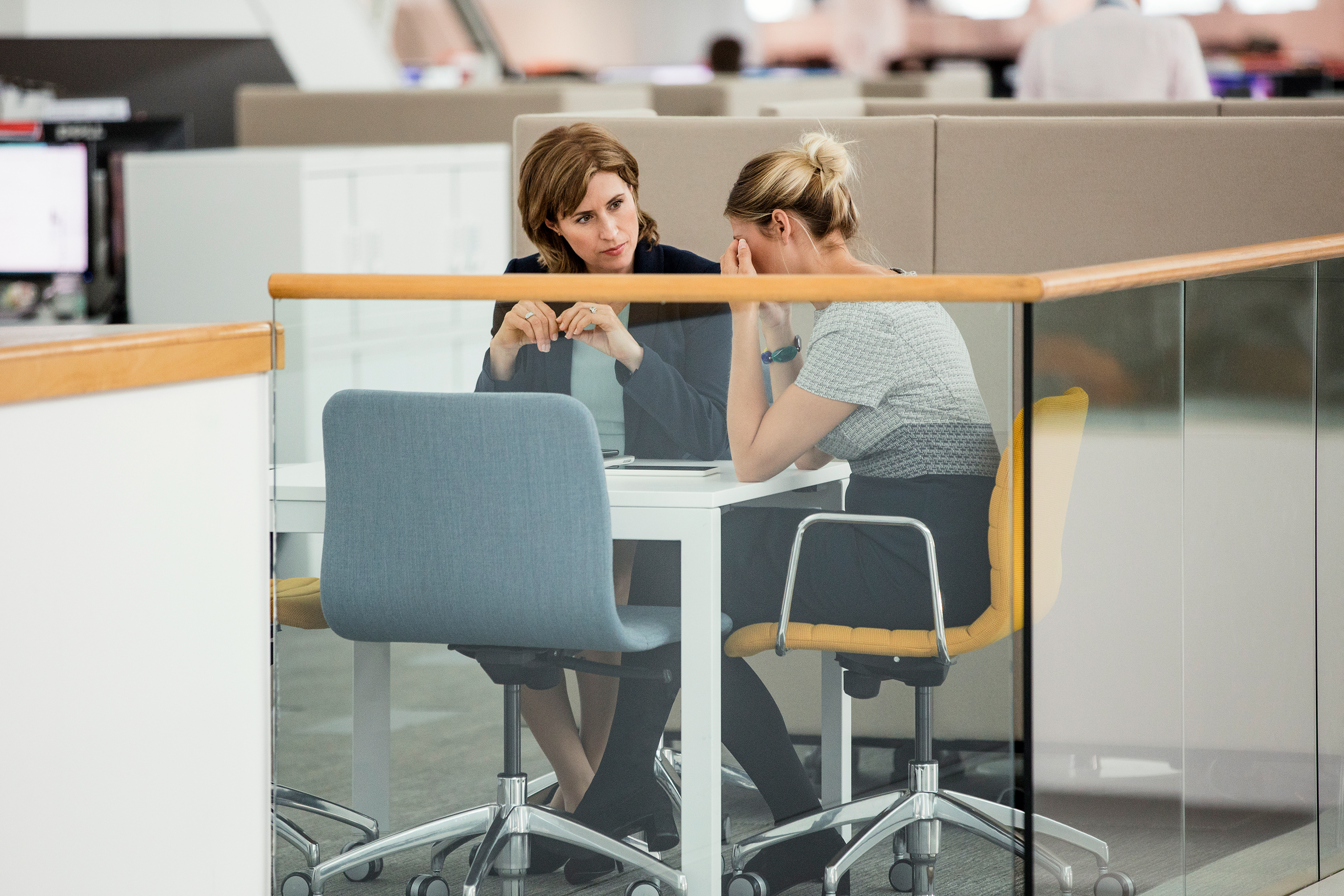 Two female colleagues having a meeting, one of them is crying upset.
