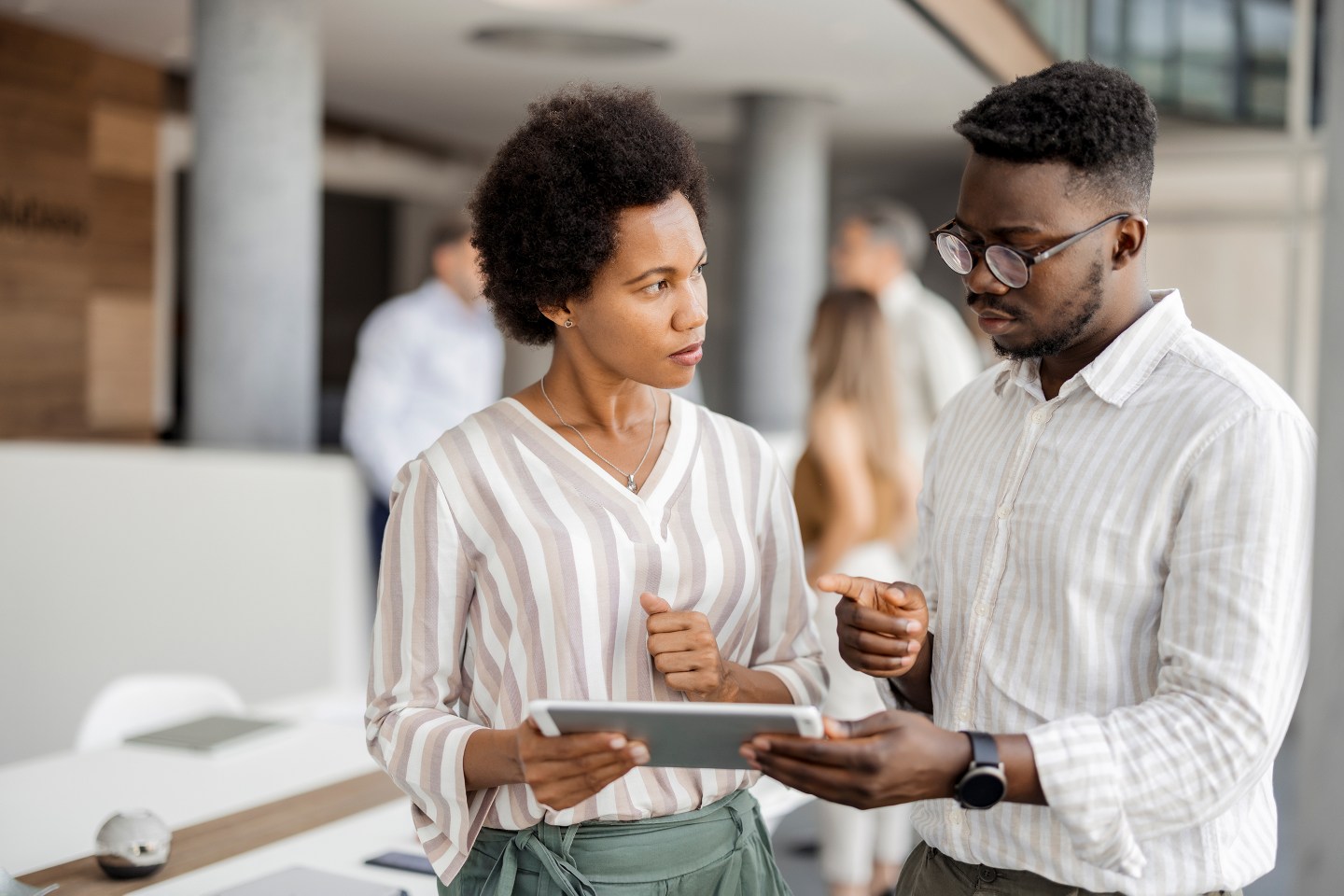 African american business partners working on digital tablet at modern office