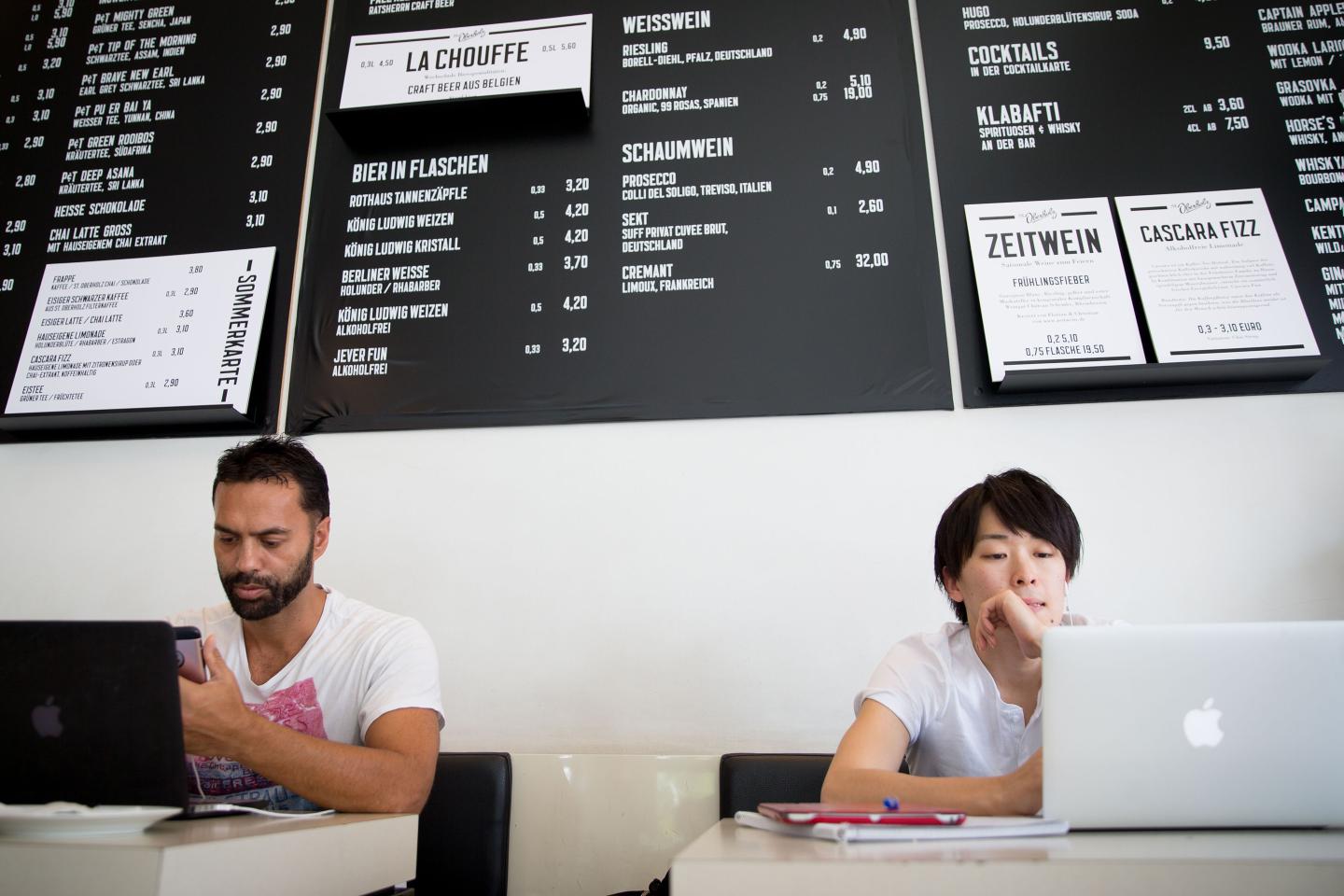 Customers work on their laptops on the internet in the cafe St. Oberholz in Berlin-Mitte, Germany.