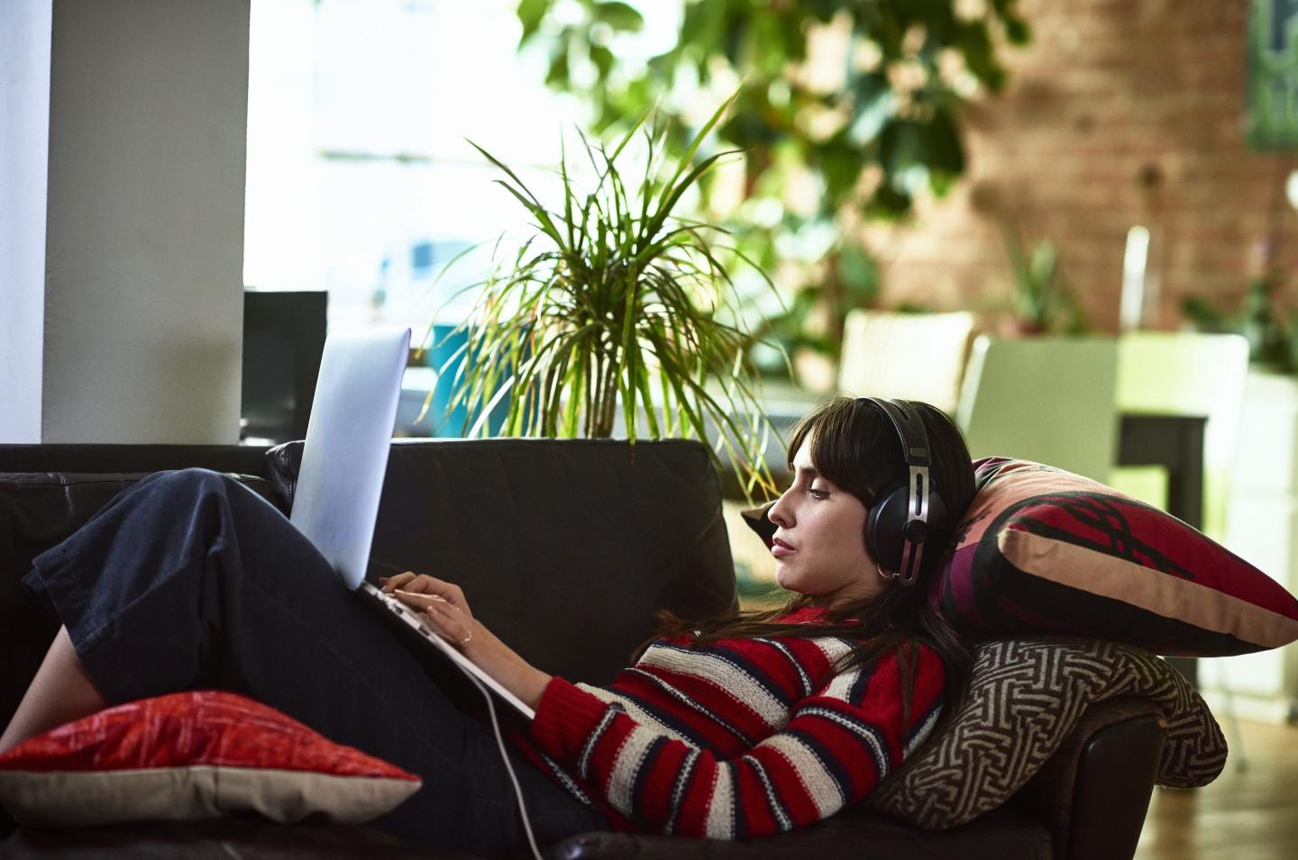 Young woman listening to music and working from home.